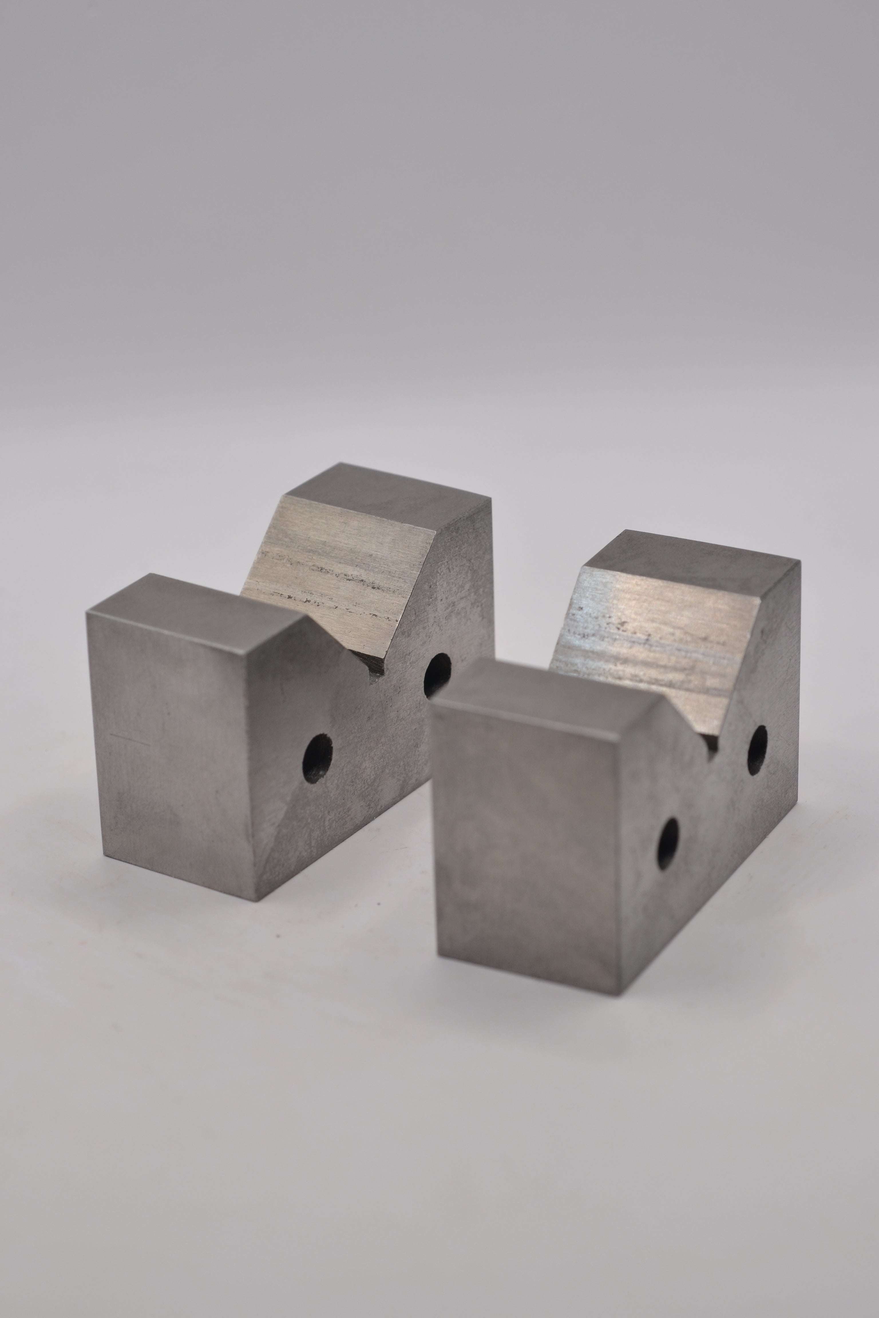 Set of two cast iron ring mandrel holders for supporting a jewellery ring mandrel during wax carving and jewellery making.