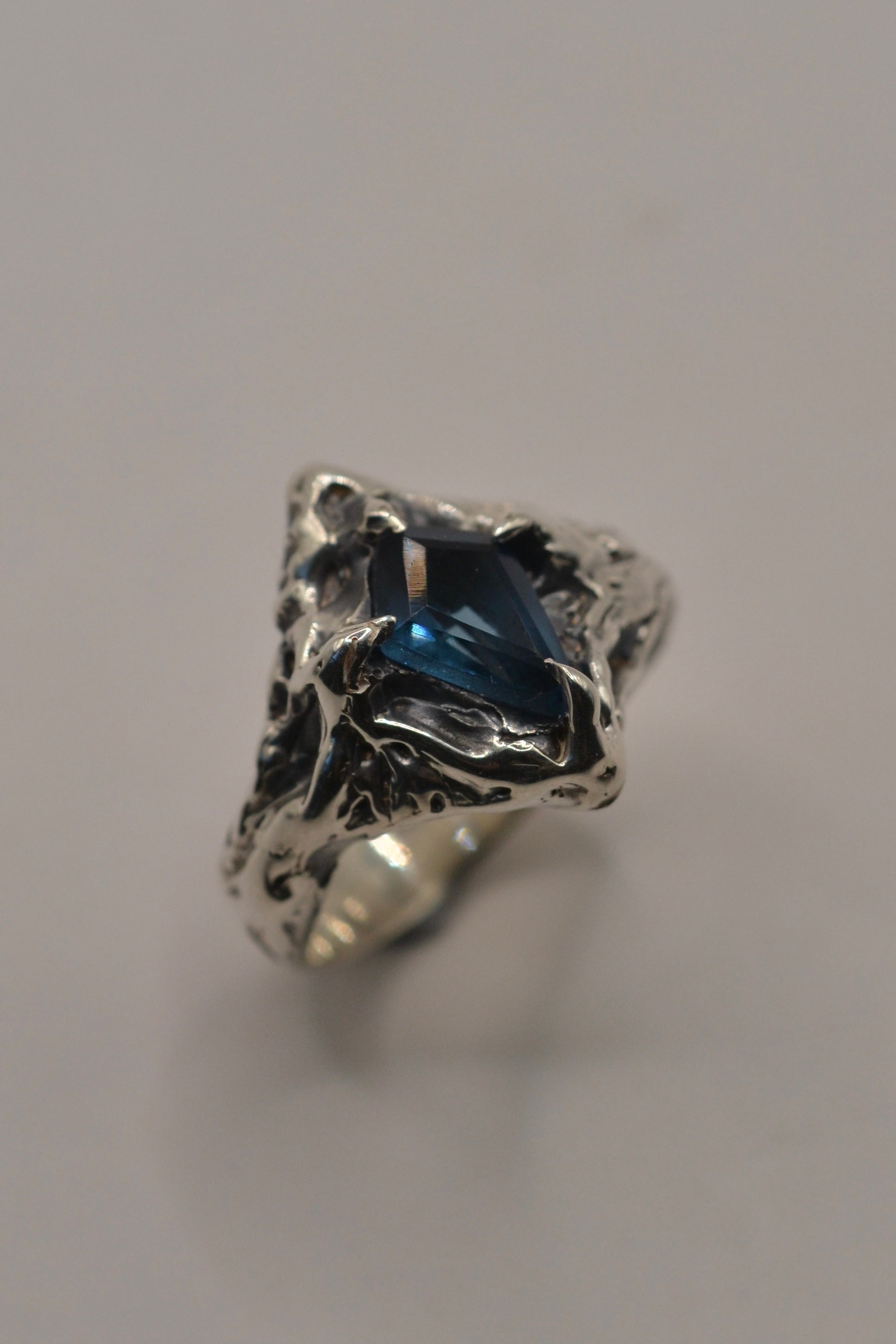 The Morticia Ring is a handmade lost wax carving creation, blending 925 sterling silver with a striking kite-cut topaz, finished with a deep patina for an enchanting, moody aesthetic.