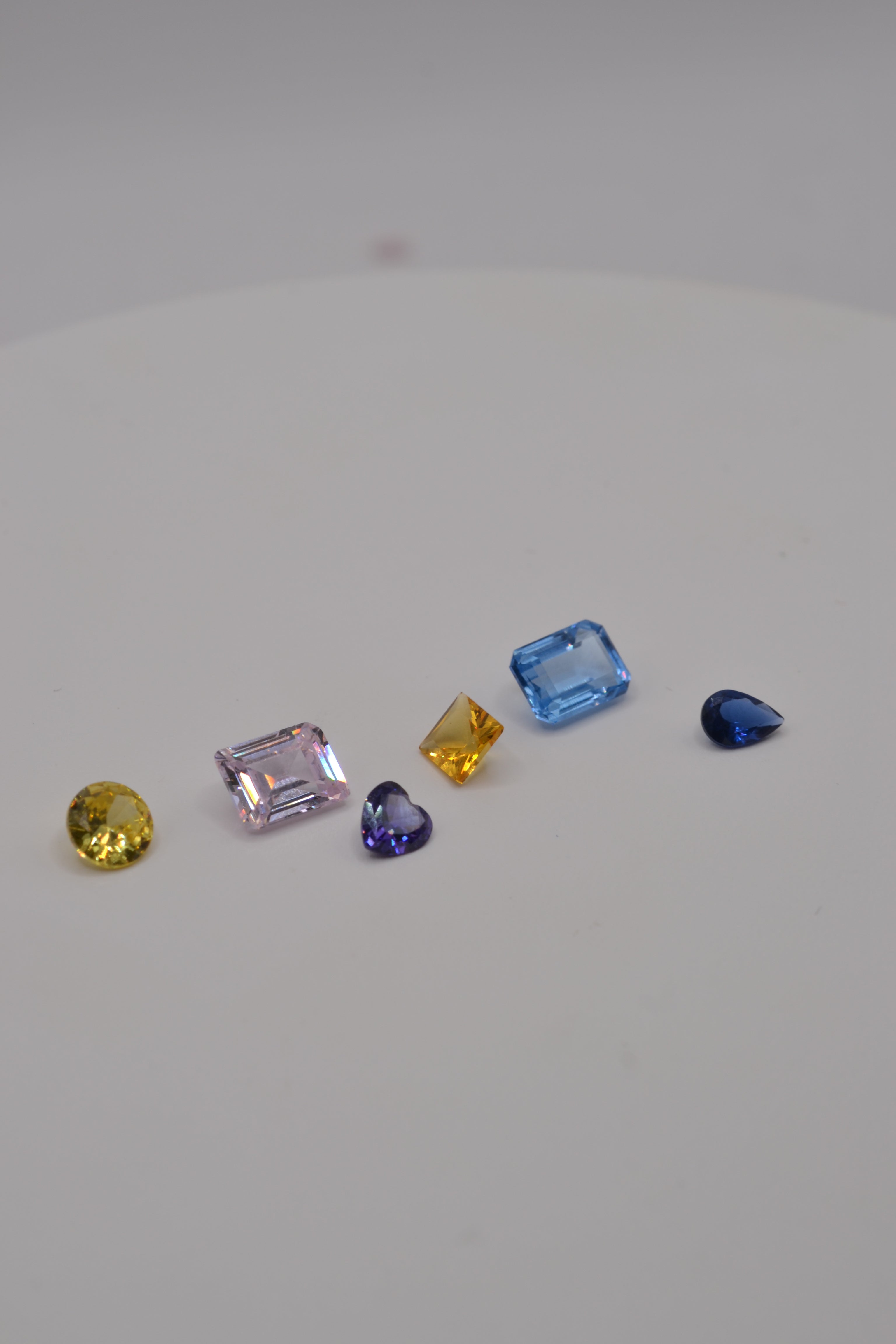 Multi coloured fancy cut gemstones for cast in place designs using the lost wax method side view