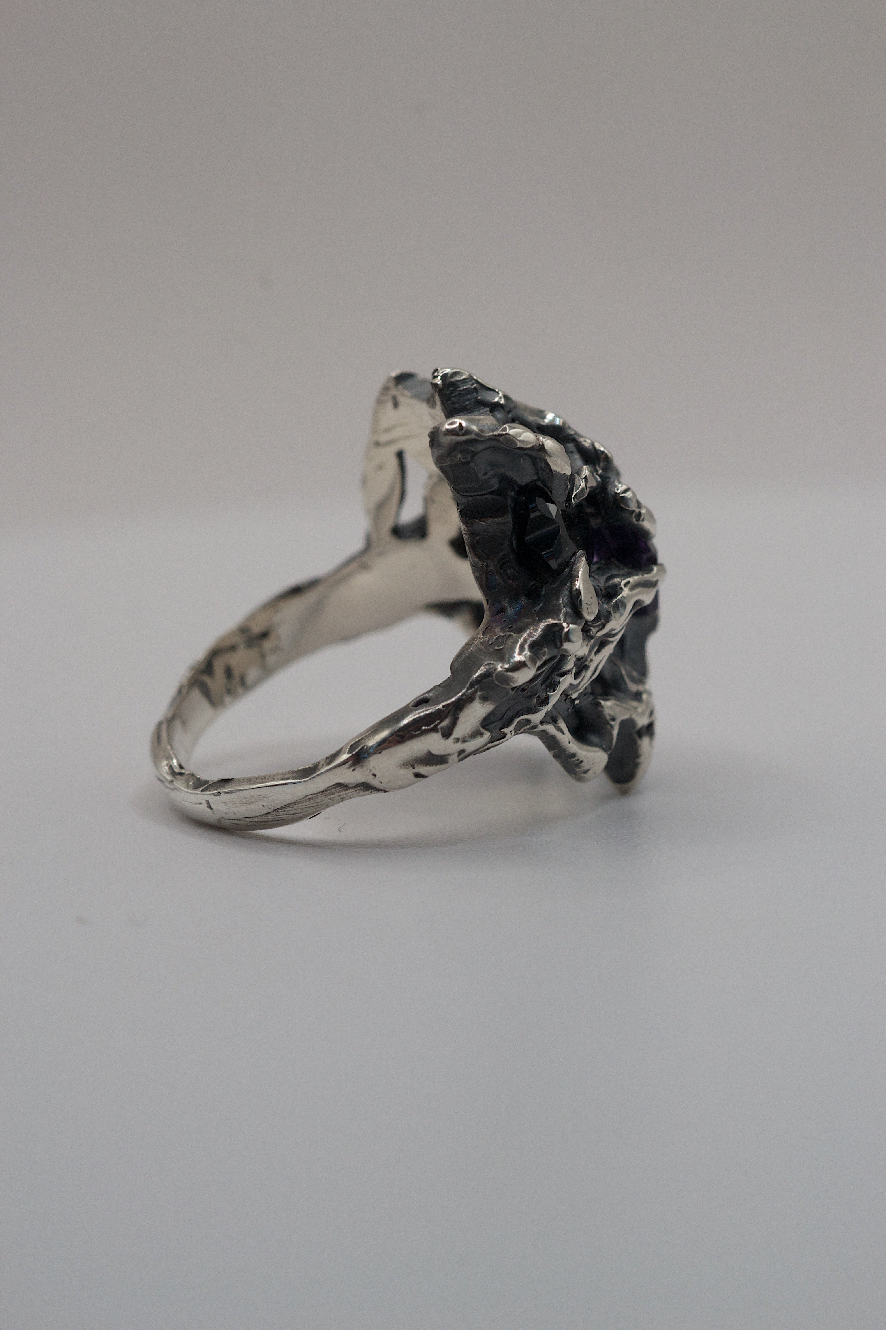 Handmade brutalist ring in sterling silver featuring two contrasting gemstones and a heavy clawed aesthetic.