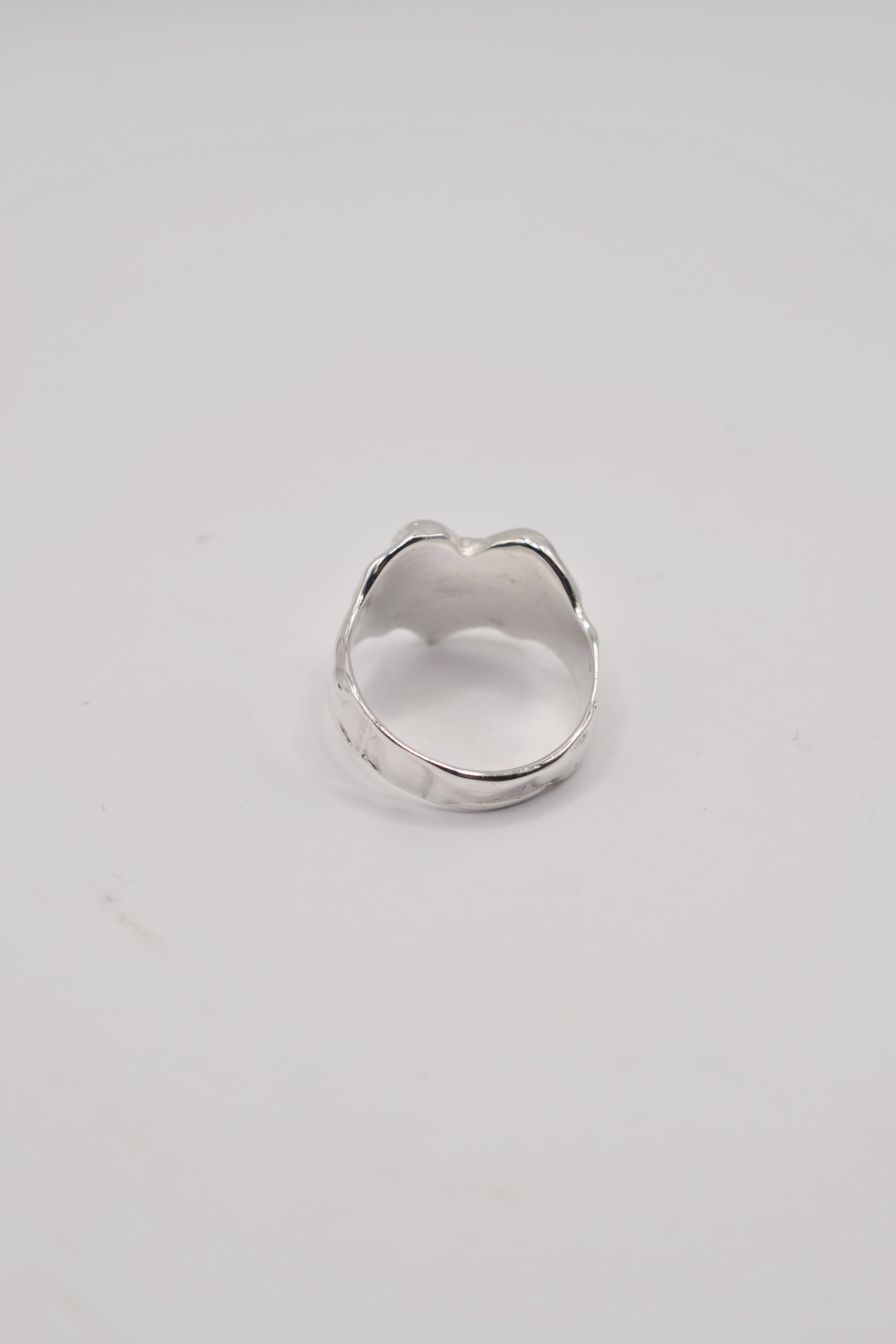 Back view of organic lost wax cast ring in sterling silver with hand carved texture and solid band