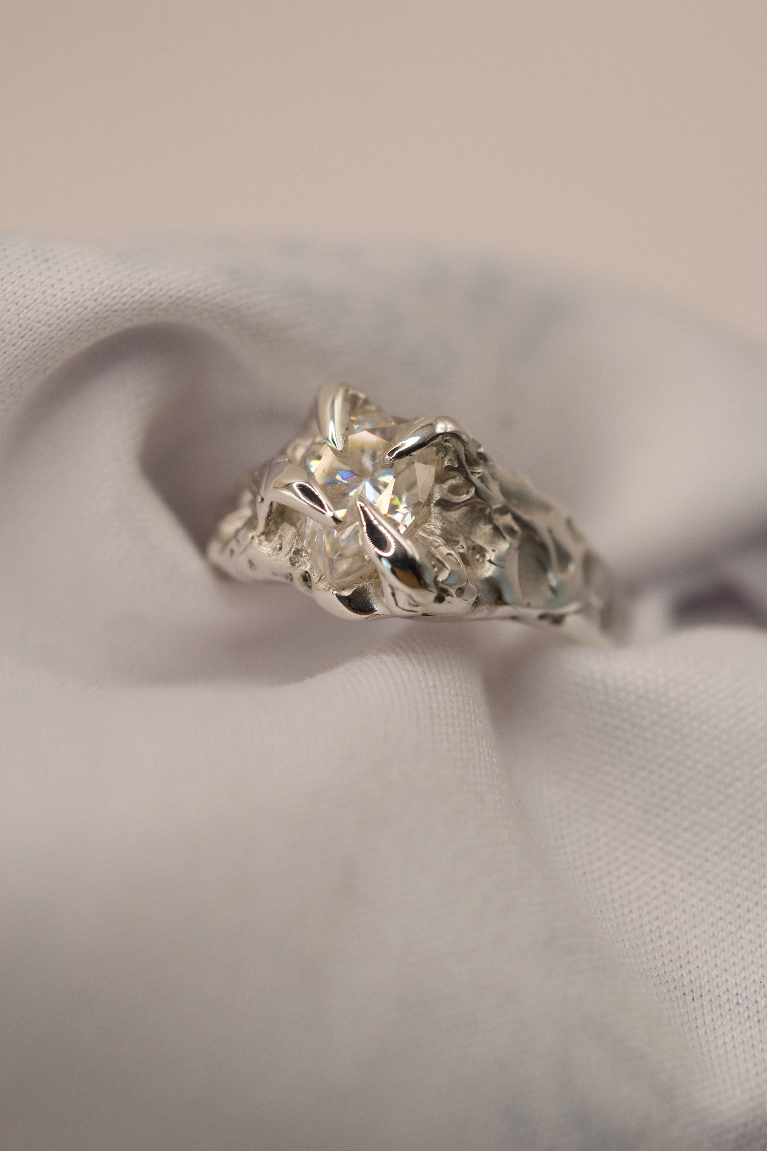 Sterling silver handmade lost wax engagement ring with gothic inspired claws and a pear cut moissanite, designed as an organic alternative ring.