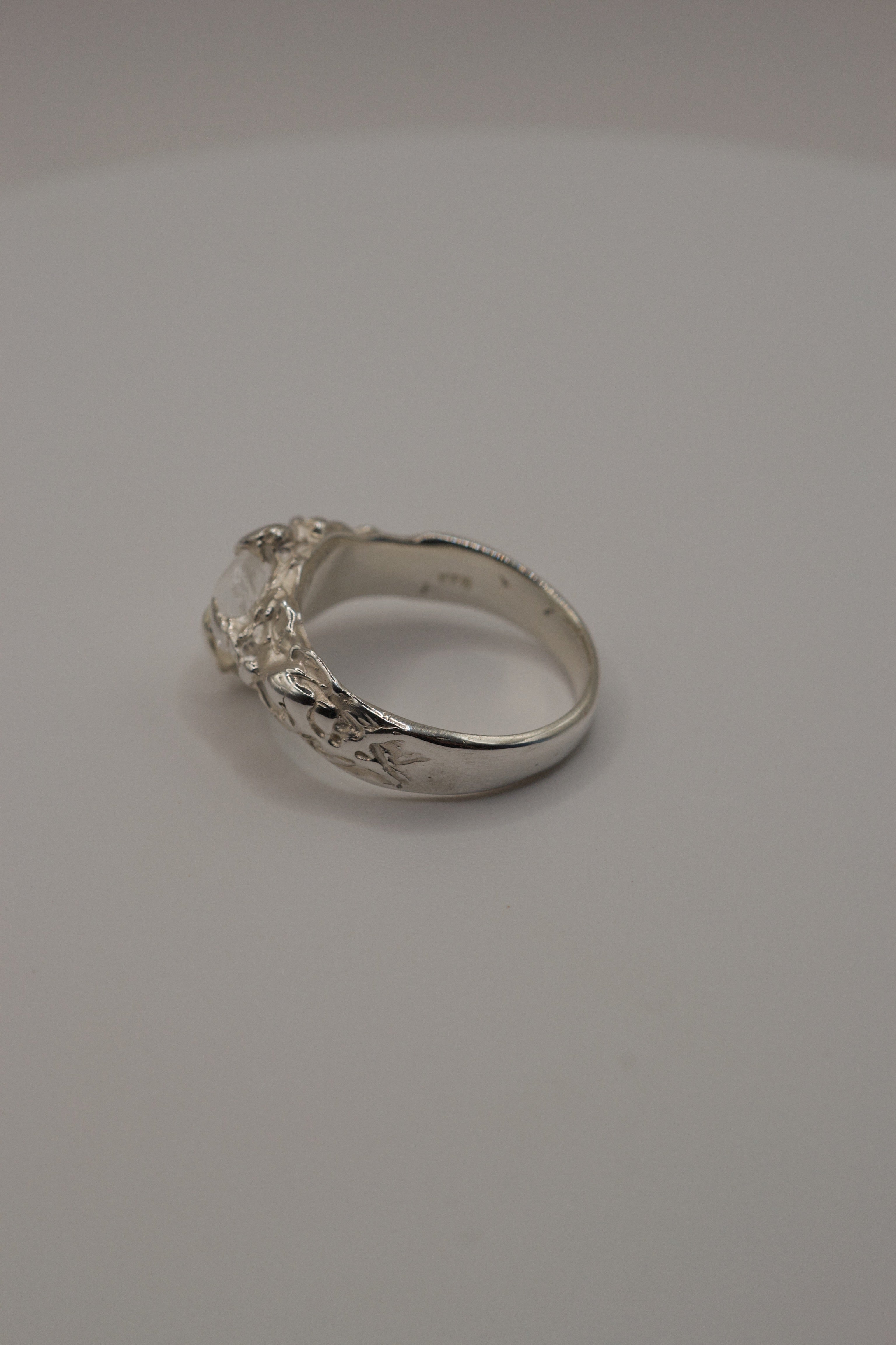 Handmade lost wax sterling silver ring, organic molten band with irregular clear quartz gemstone, side detail close-up.