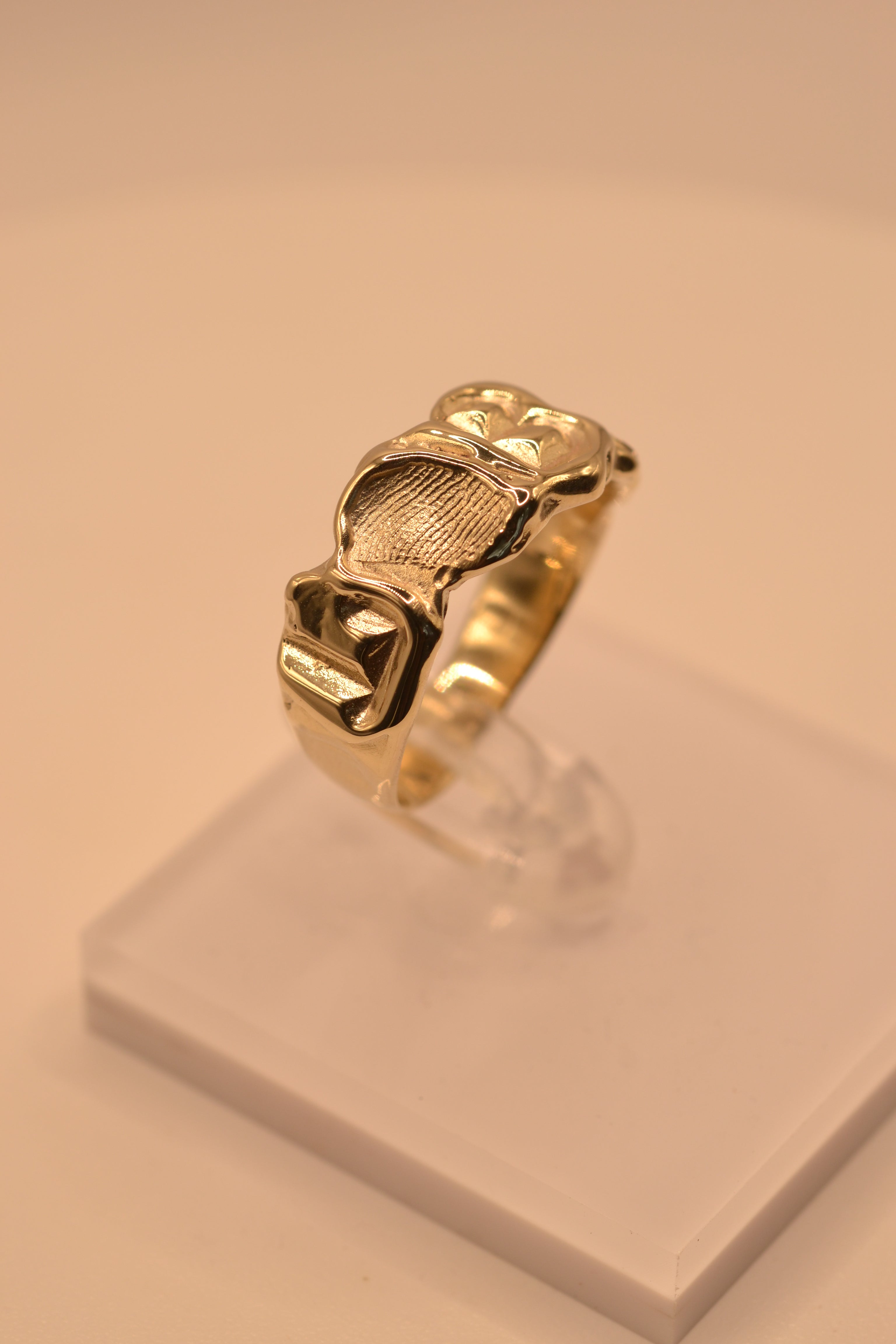 Close up of handmade gold molten initial ring showing organic wax cast surface and letter detail