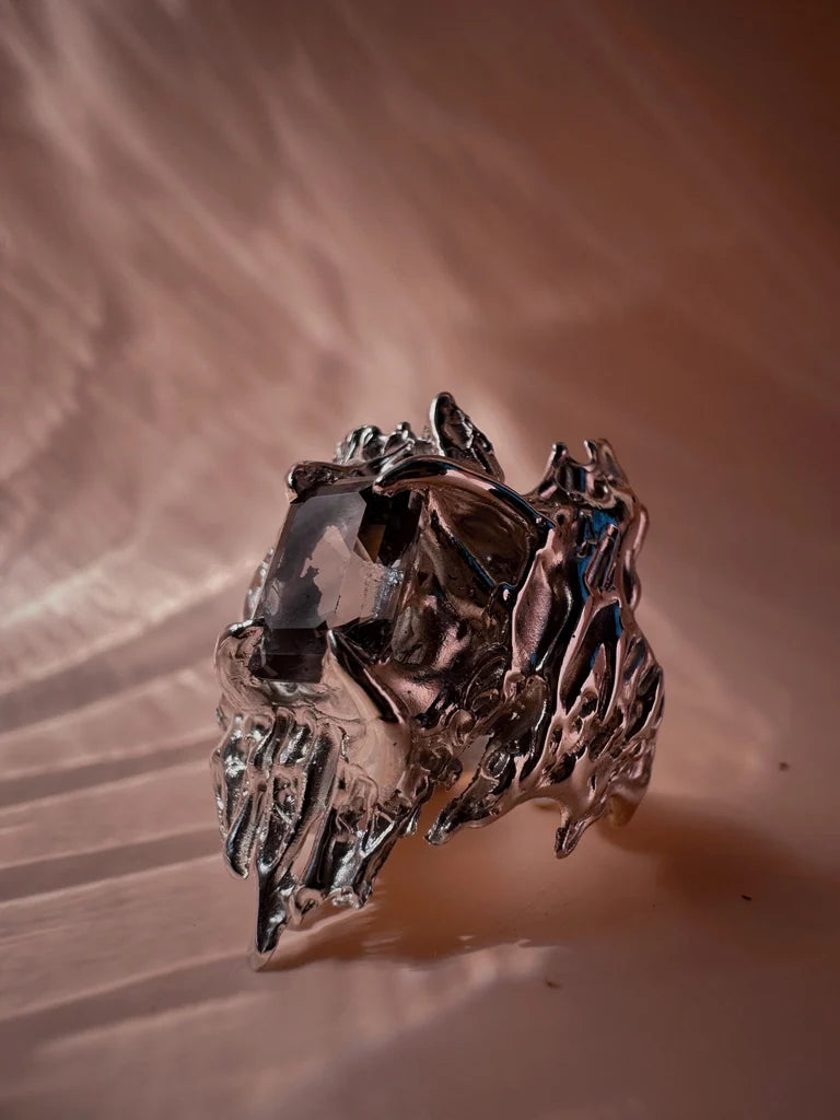 Gothic and organic style lost wax cast sterling silver ring with sharp edges. Four gothic style claws holding a grey lab grown nano crystal which was cast in place in the lost wax casting process. This is a side view of the ring.