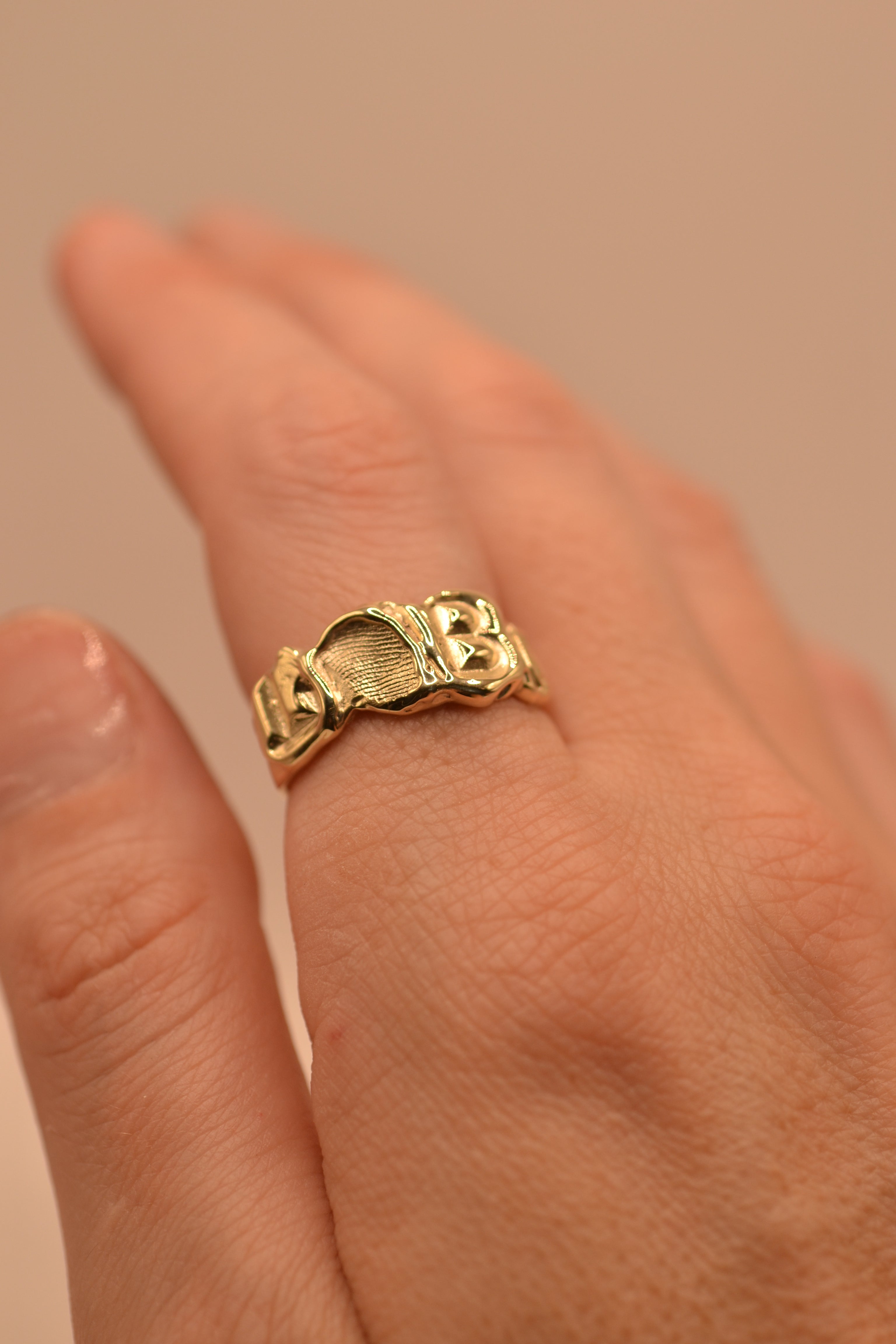 Overhead view of handmade gold molten personalised band ring showing initial placement and band shape