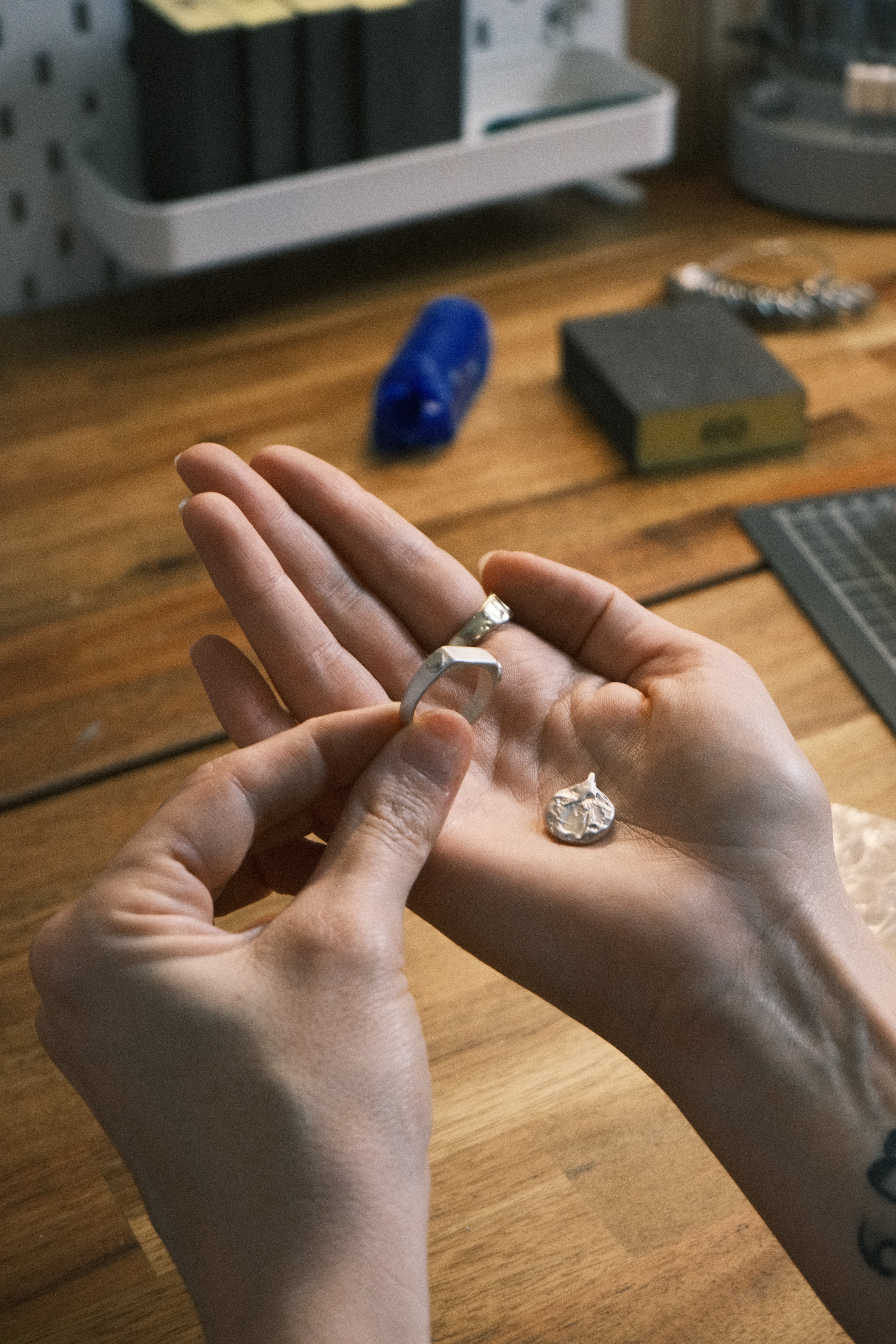 Hand holding raw jewellery castings created through the lost wax casting and investment casting process before refining and polishing.