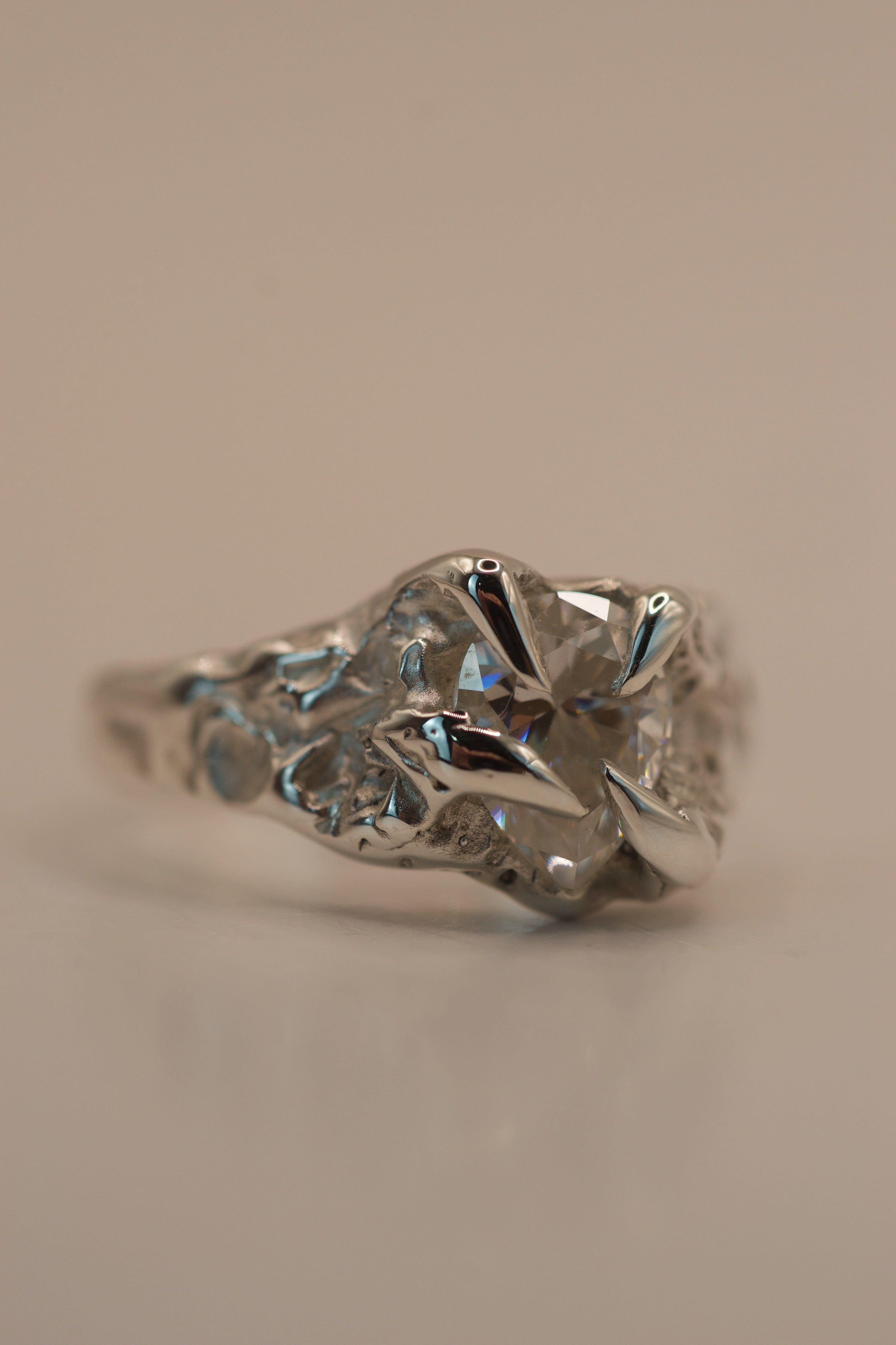 Organic alternative engagement ring in sterling silver, handmade with the lost wax method, featuring gothic inspired claws and a pear cut moissanite.