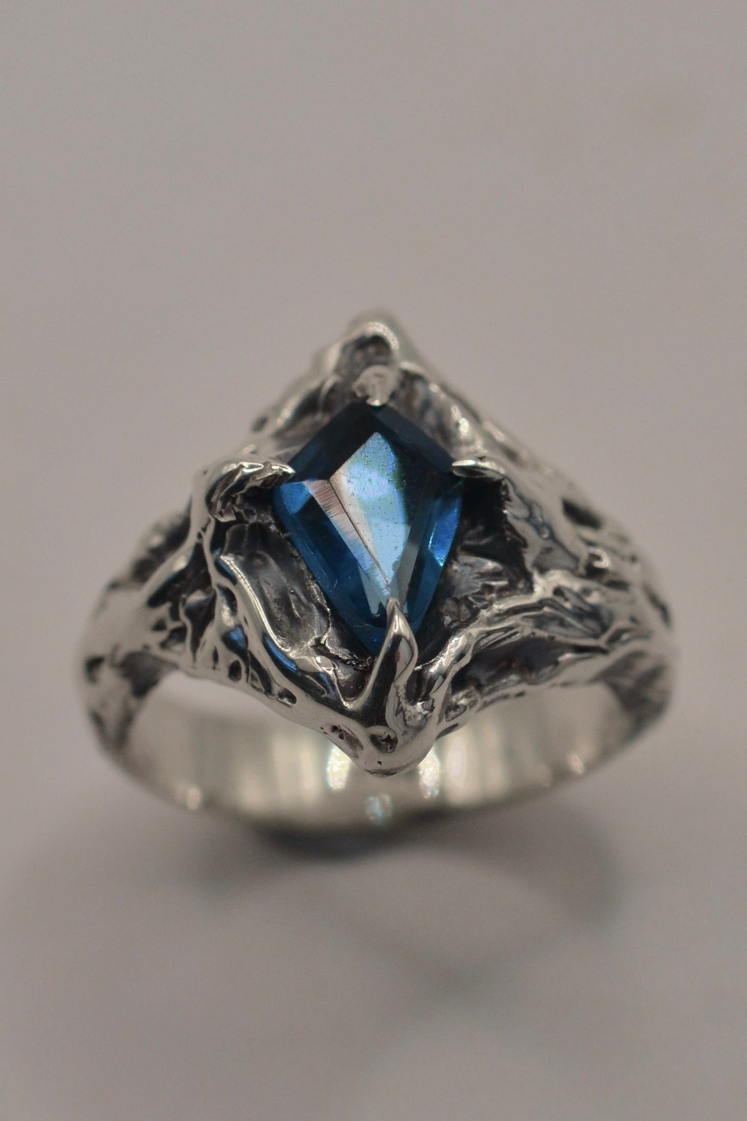A hand-sculpted sterling silver ring featuring a natural kite-cut topaz. This gothic-inspired piece is ethereal yet bold, perfect for those who love unusual engagement ring designs.