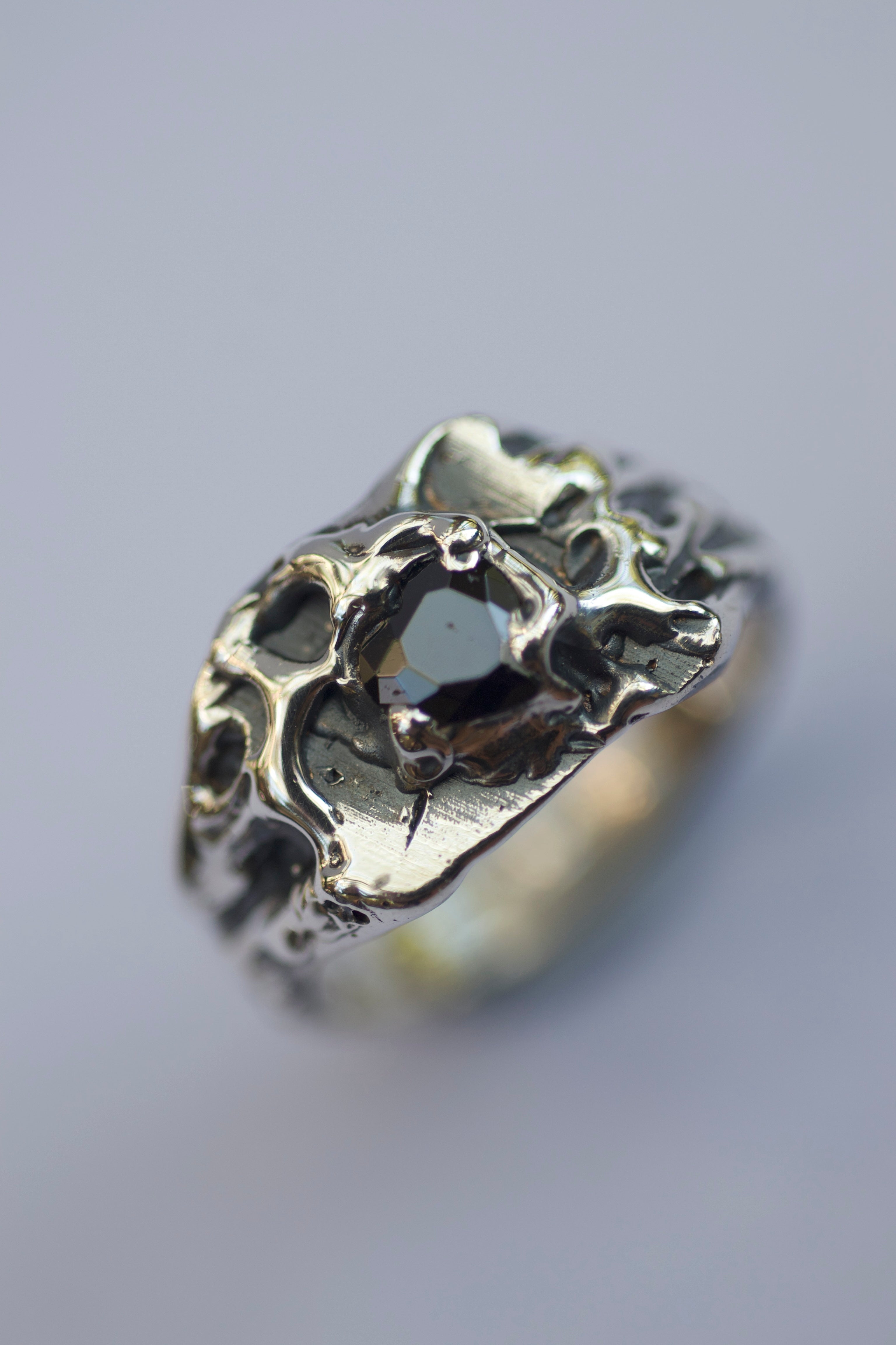 Handmade lost wax cast sterling silver ring with raw organic texture and dark romantic detail holding a black heart cubic zirconia, moody gothic inspired alternative ring made using the wax carving technique