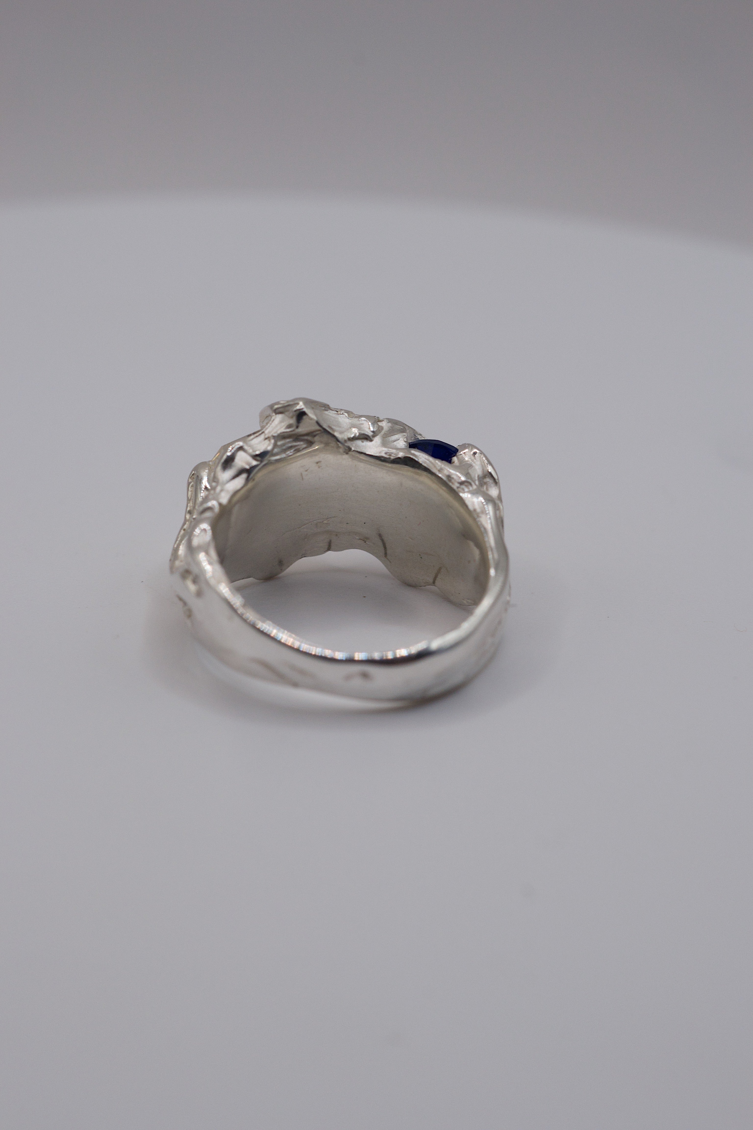 Side profile of the Blue Crush Ring showing organic recycled sterling silver band with natural blue sapphire and moissanite alternative ring