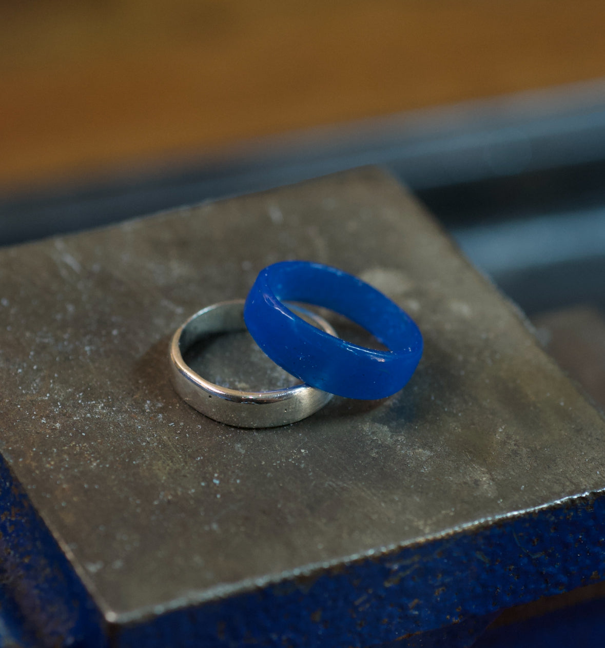 Blue carving wax ring next to a finished cast sterling silver ring showing the before and after of the lost wax jewellery making process