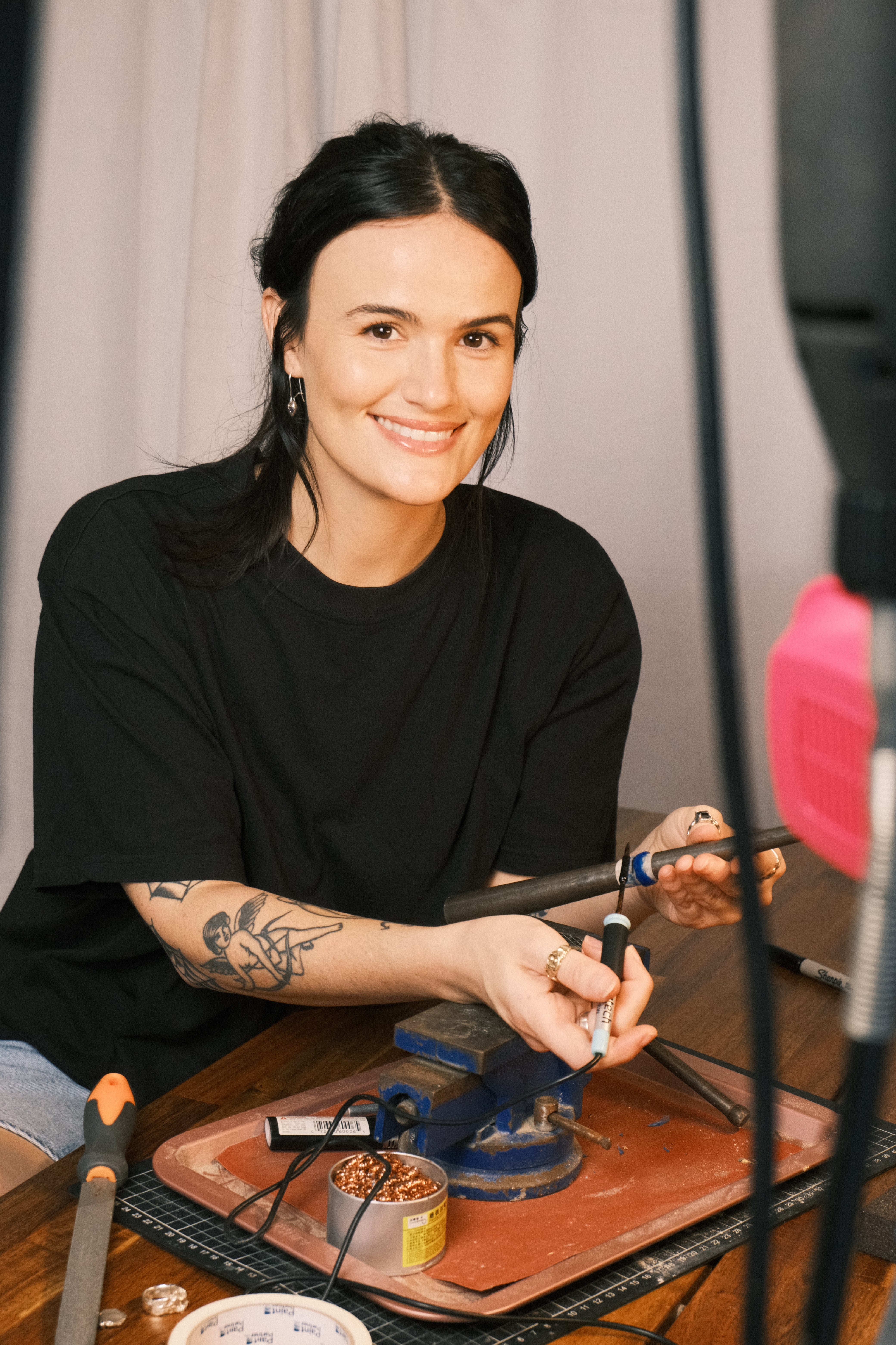 Cassandra Djodan smiling in her jewellery studio on the Sunshine Coast holding jewellery making tools, creator of the lost wax jewellery making online course