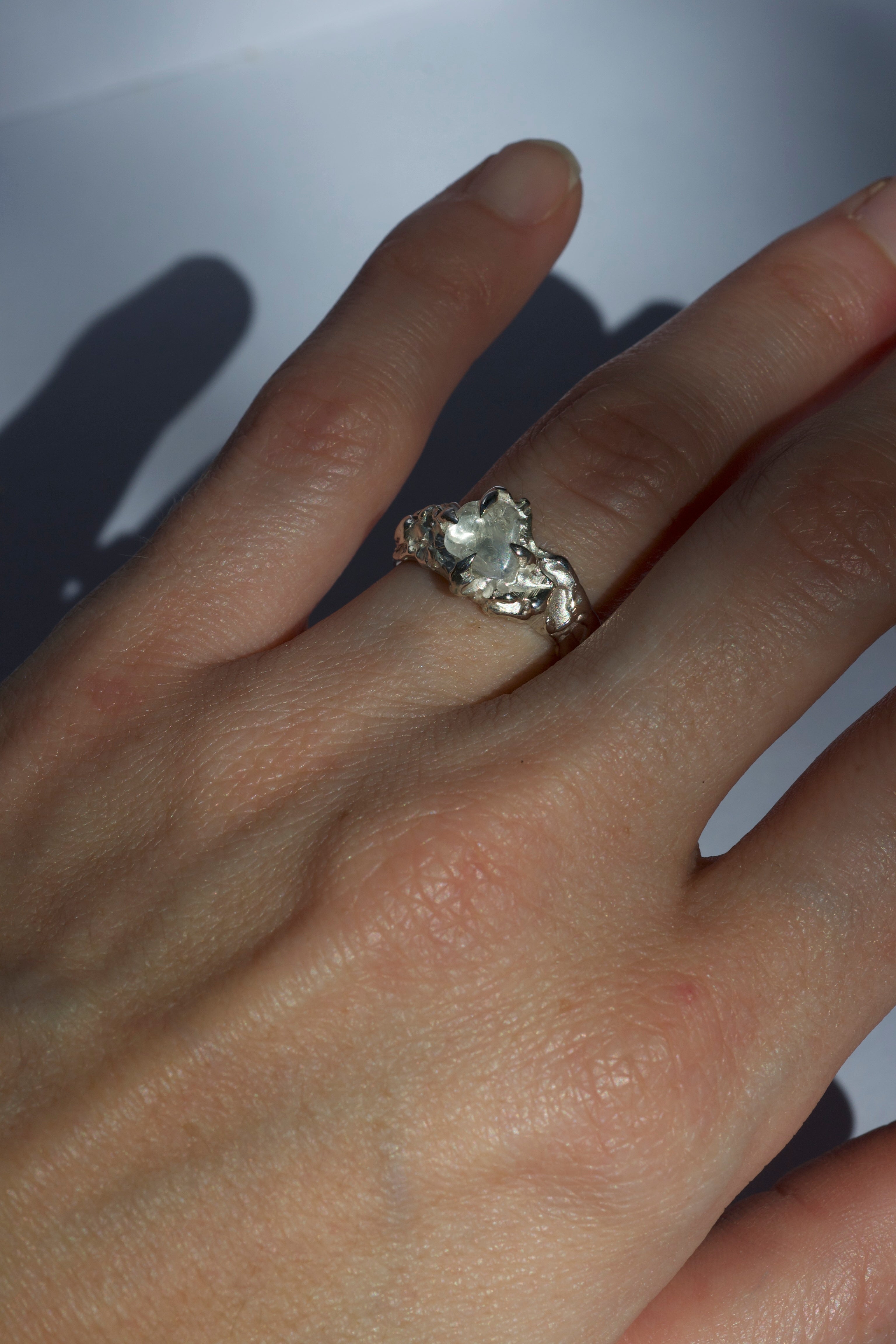 Lost wax cast silver Cloud Nine Ring worn on hand with natural clear quartz and ethereal organic silver setting