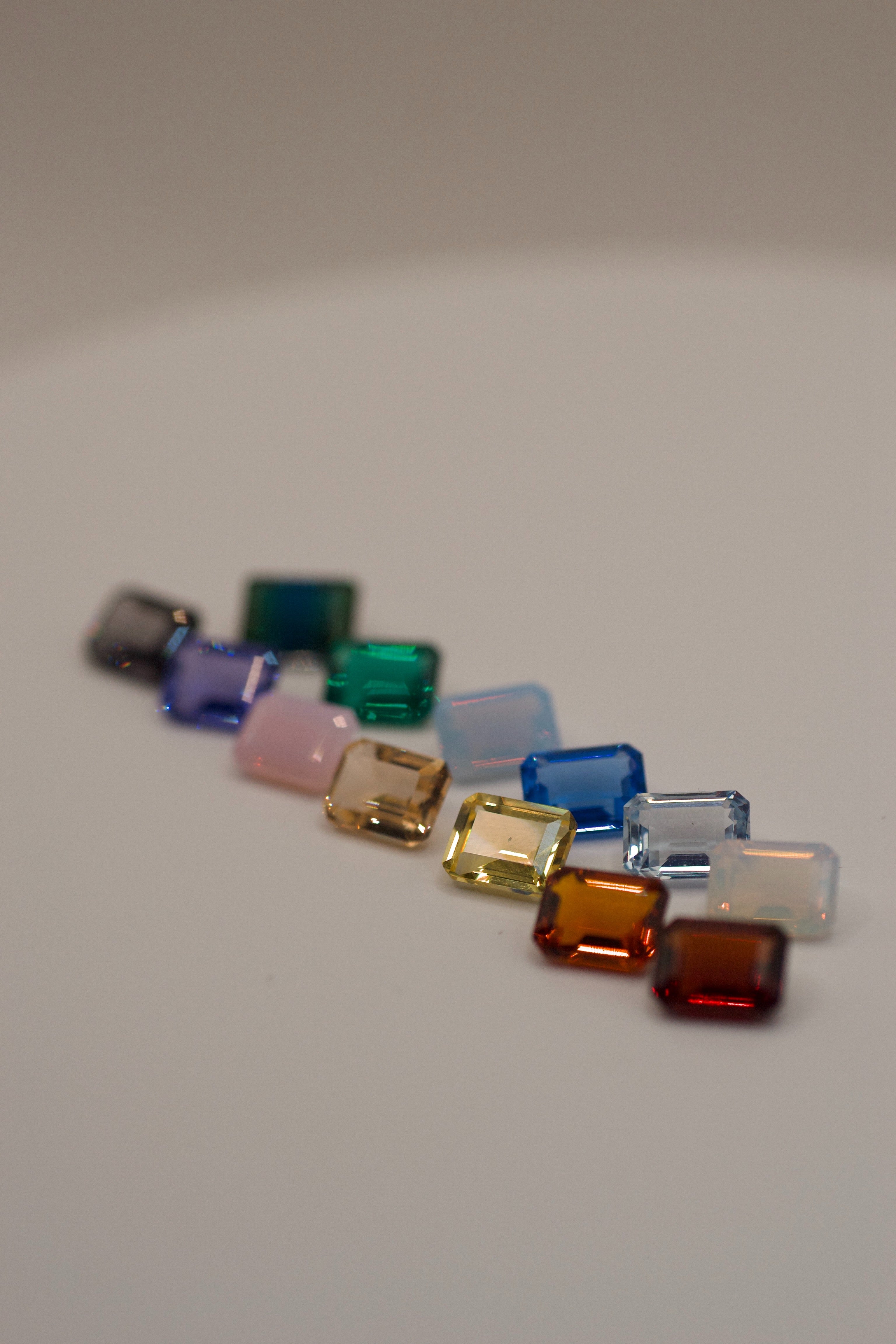 Flat lay of gemstone colour options available for the lost wax cast silver Dragon Ring handmade sculptural alternative engagement ring made using the wax carving technique
