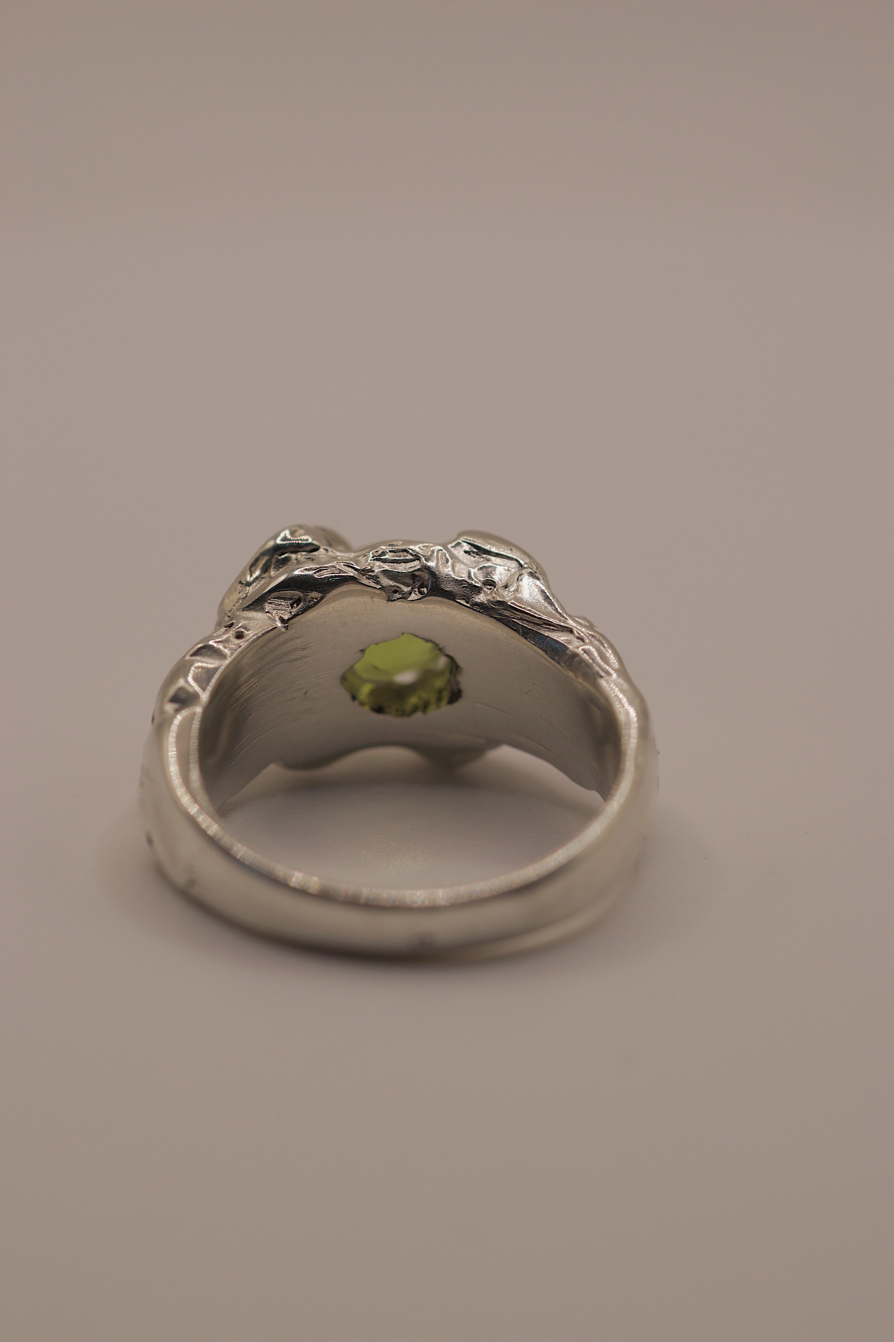 Top down view of the Fern Ring showing cushion cut lab-grown peridot set within organic textured molten sterling silver handmade using lost wax casting