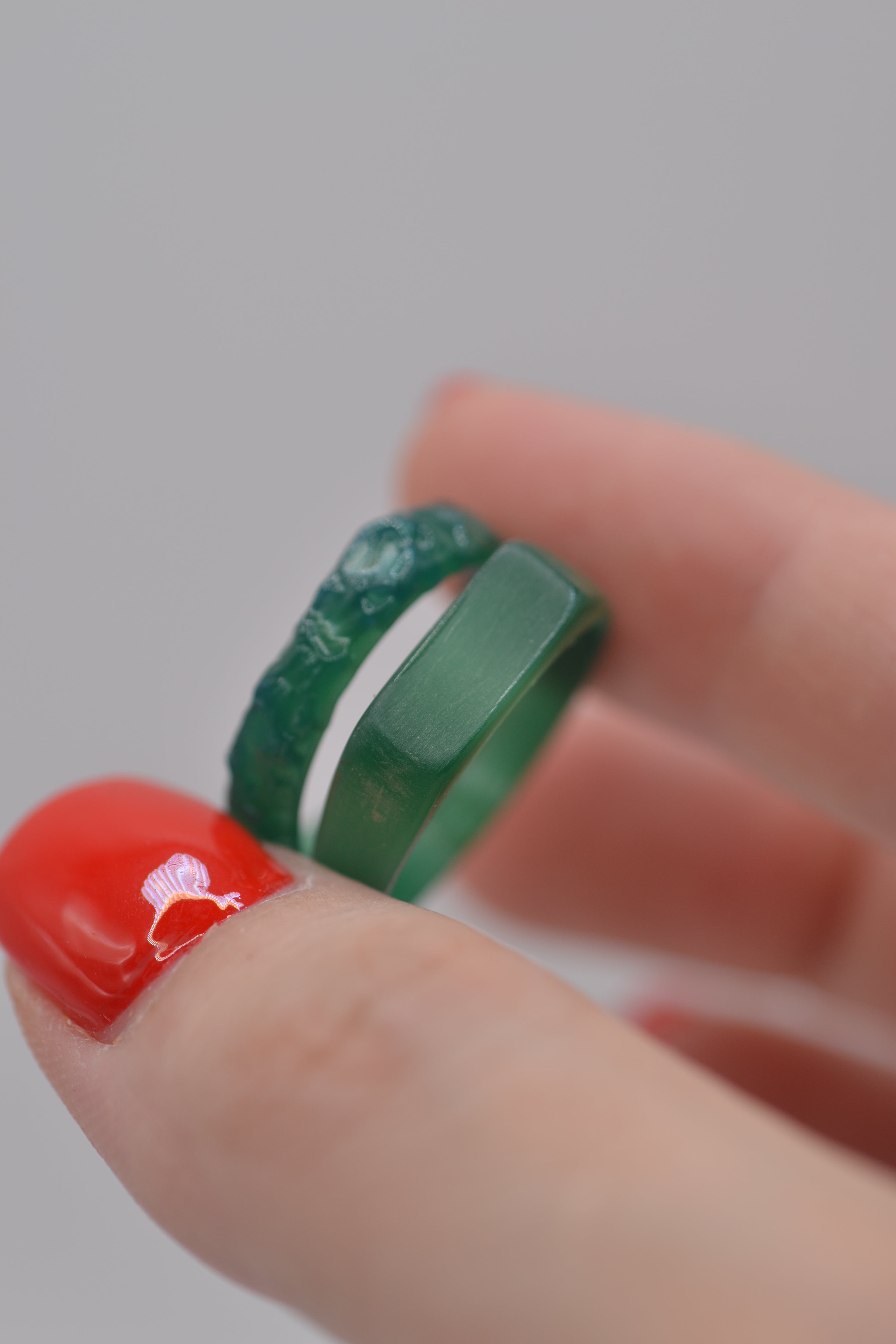 two green ferris wax carved rings in hand