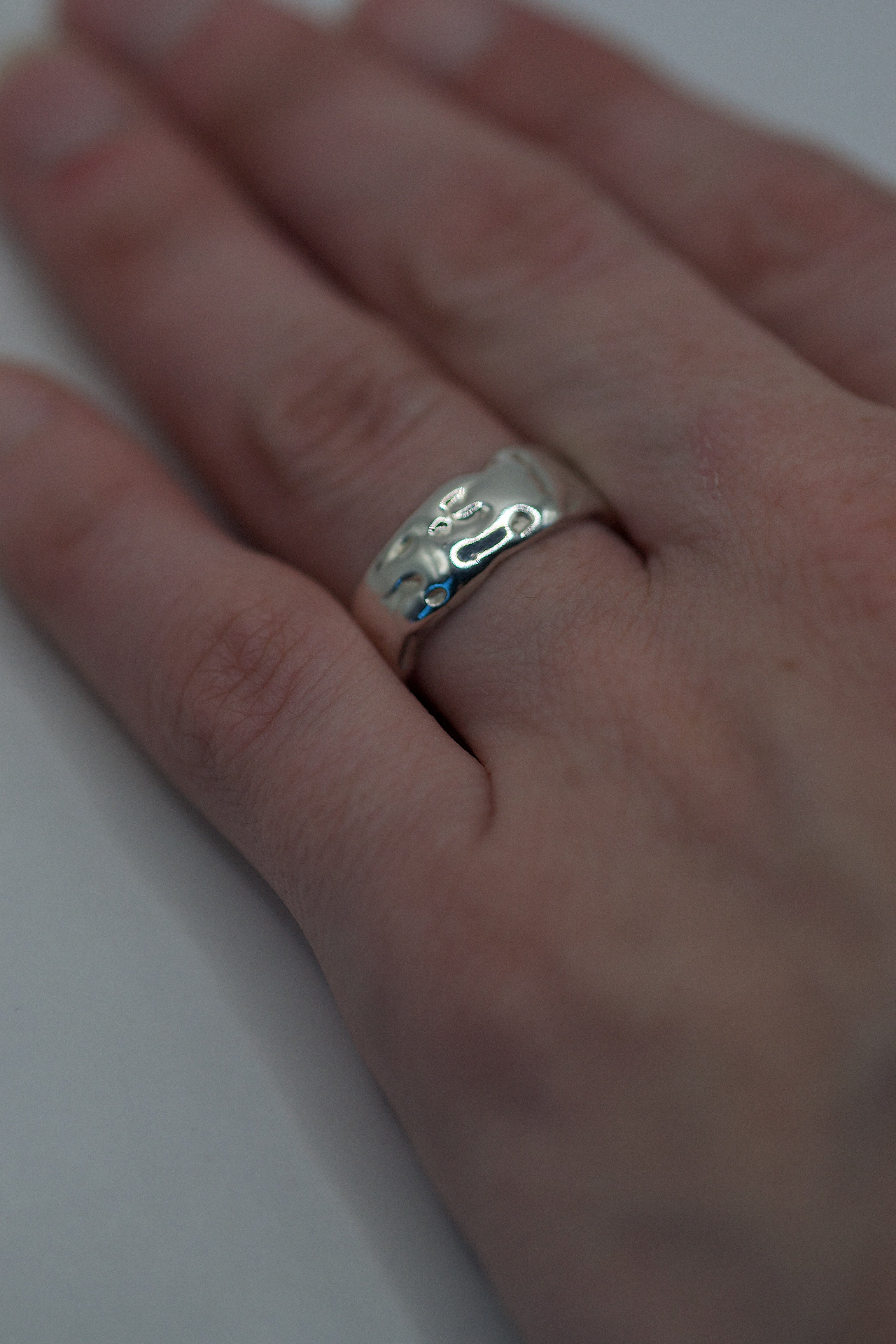 Fourth angle of the Molten Ring worn on hand showing organic flowing recycled sterling silver band lost wax cast