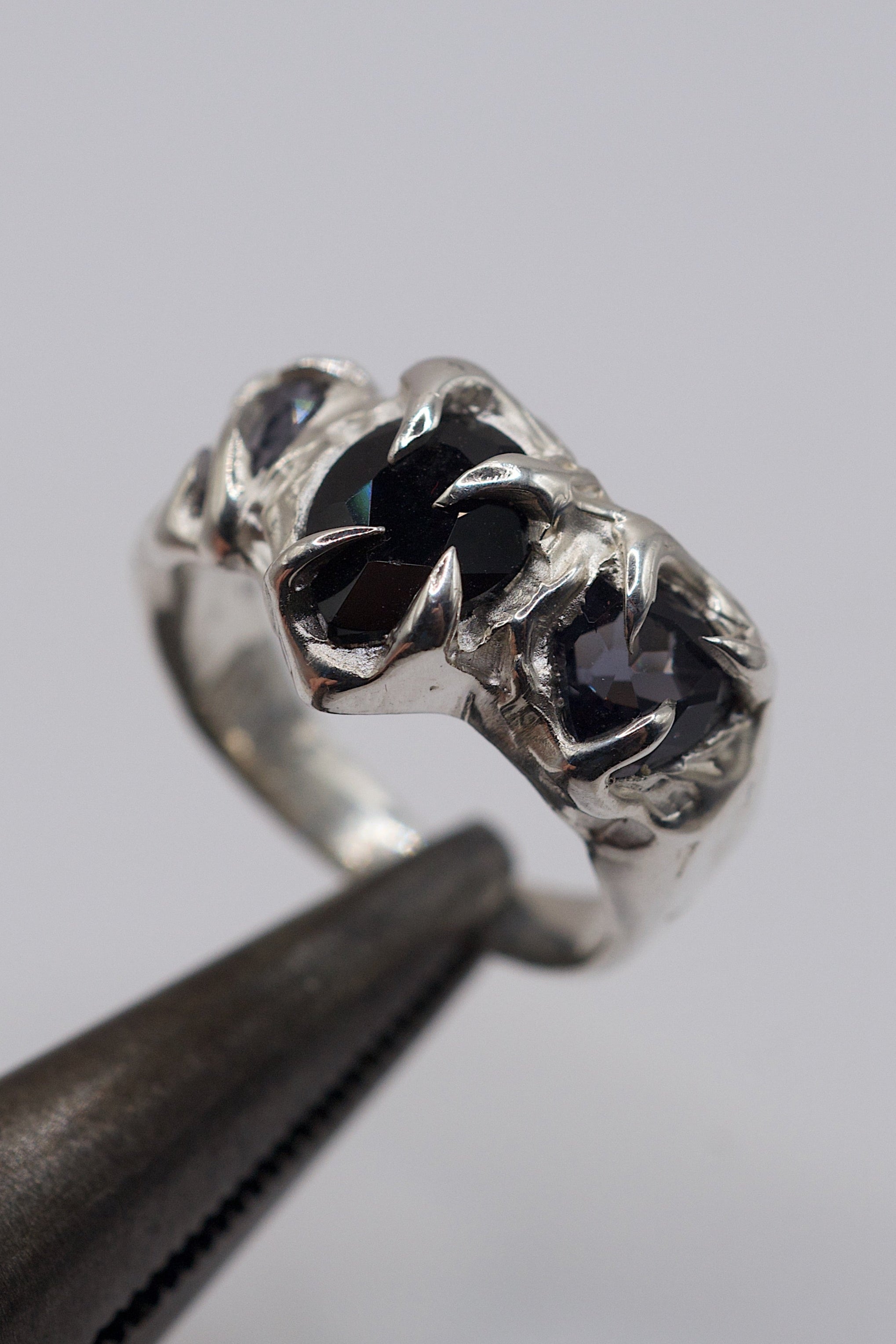 Close up of the Mourning Veil Ring showing black lab-grown onyx and spinel set within sharp sterling silver claws handmade using the lost wax technique