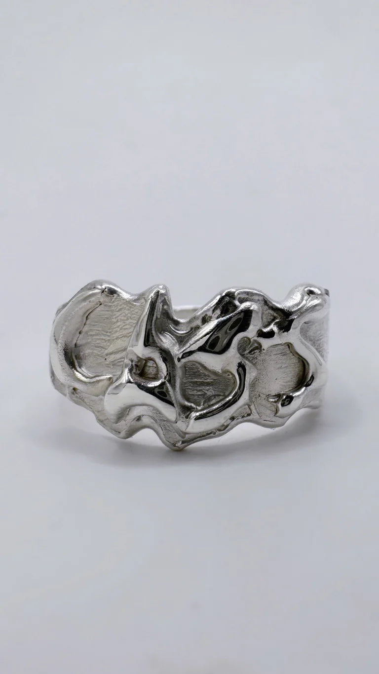 Handmade lost wax cast sterling silver personalised name ring with raised lettering set within organic flowing molten silver, custom alternative ring made using the wax carving technique