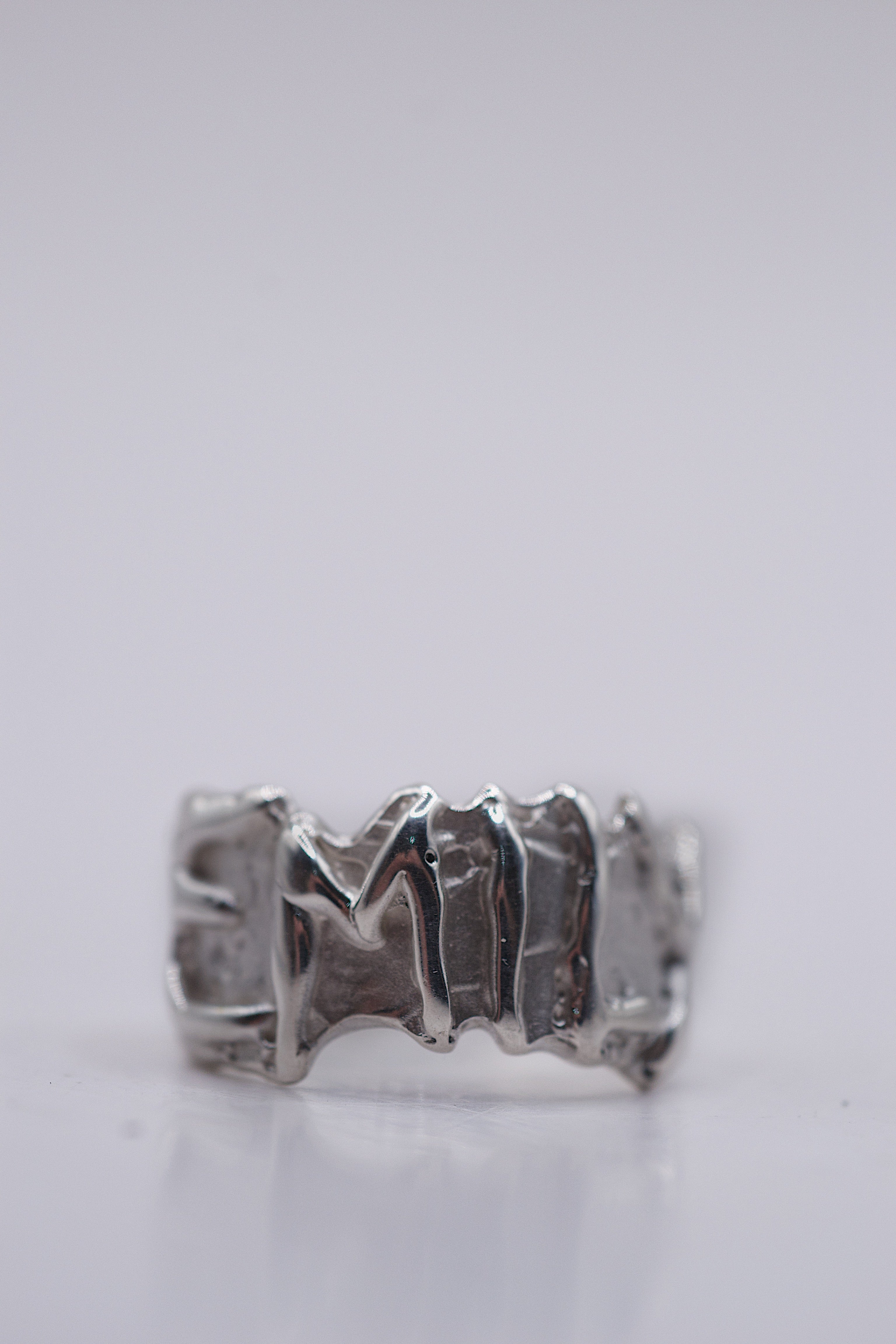 Close up of the Personalised Name Ring showing raised sterling silver lettering within organic molten silver band handmade using the lost wax technique