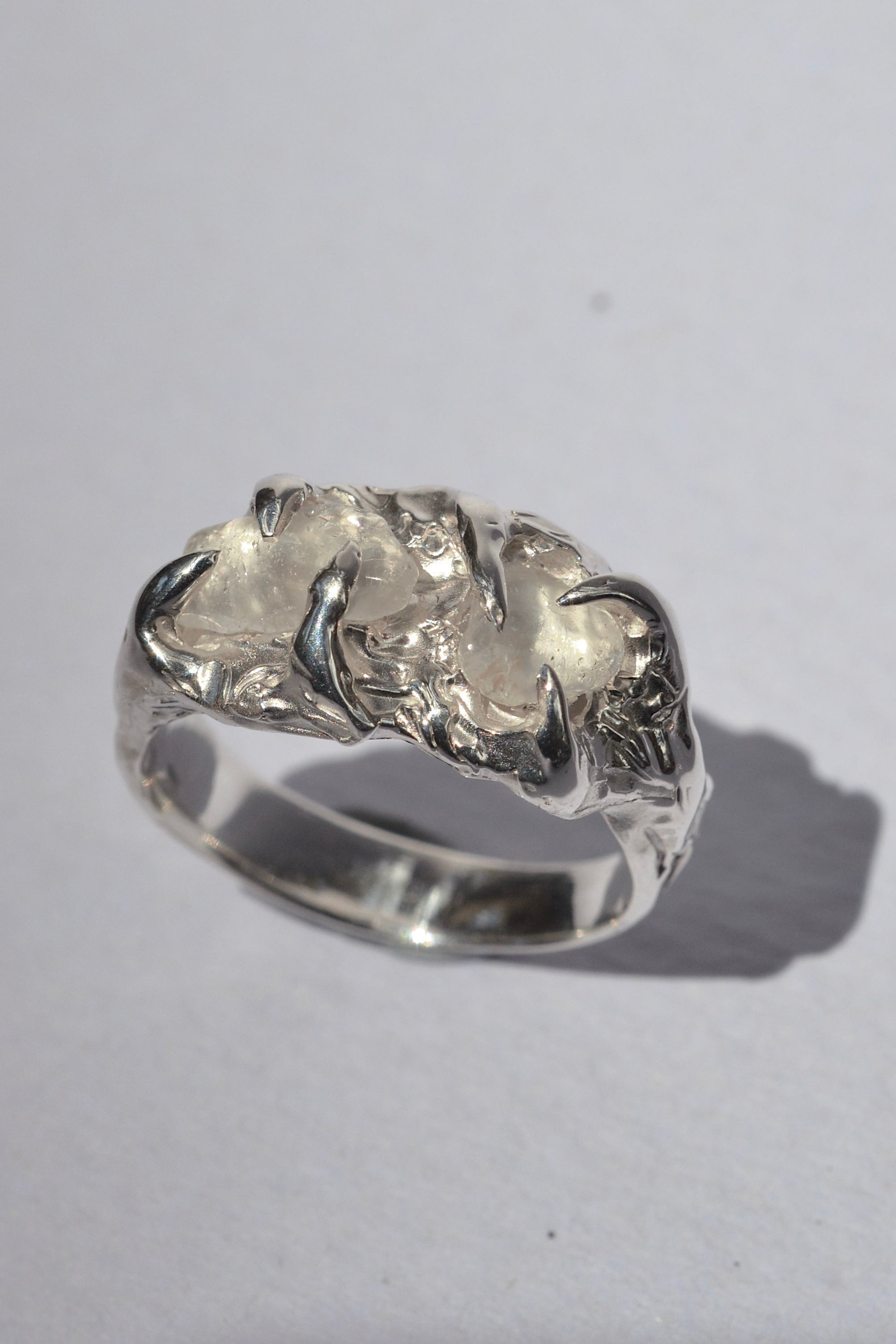 Handmade lost wax cast sterling silver ring with molten metal claws holding raw irregular quartz crystals, organic otherworldly alternative ring made using the wax carving technique
