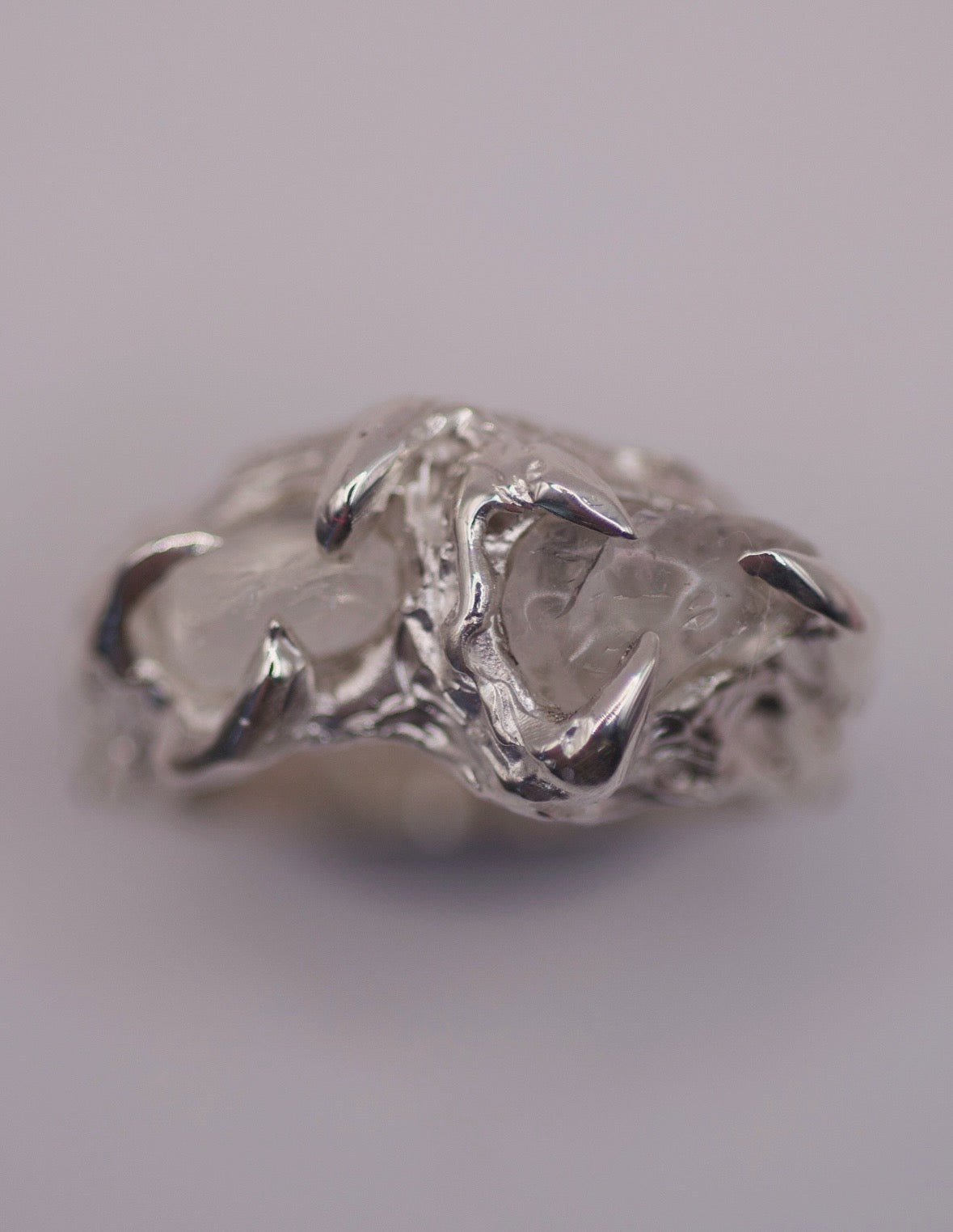 Close up of the Remnants Ring showing raw irregular quartz crystals held within organic molten sterling silver claws handmade using the lost wax technique