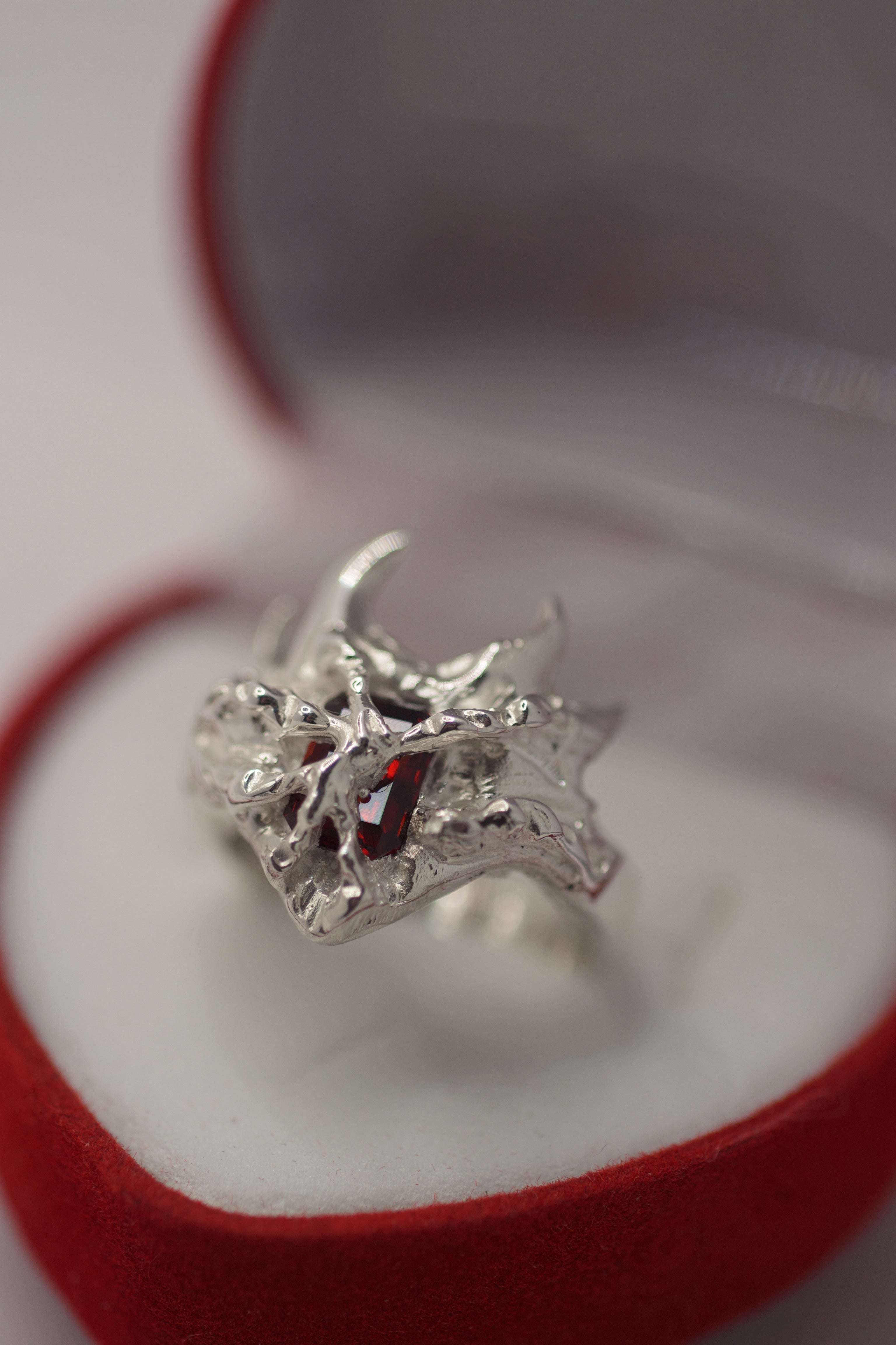 Front view of the Sacred Ring showing red lab-grown garnet within layered organic sterling silver cast using the cast-in-place technique