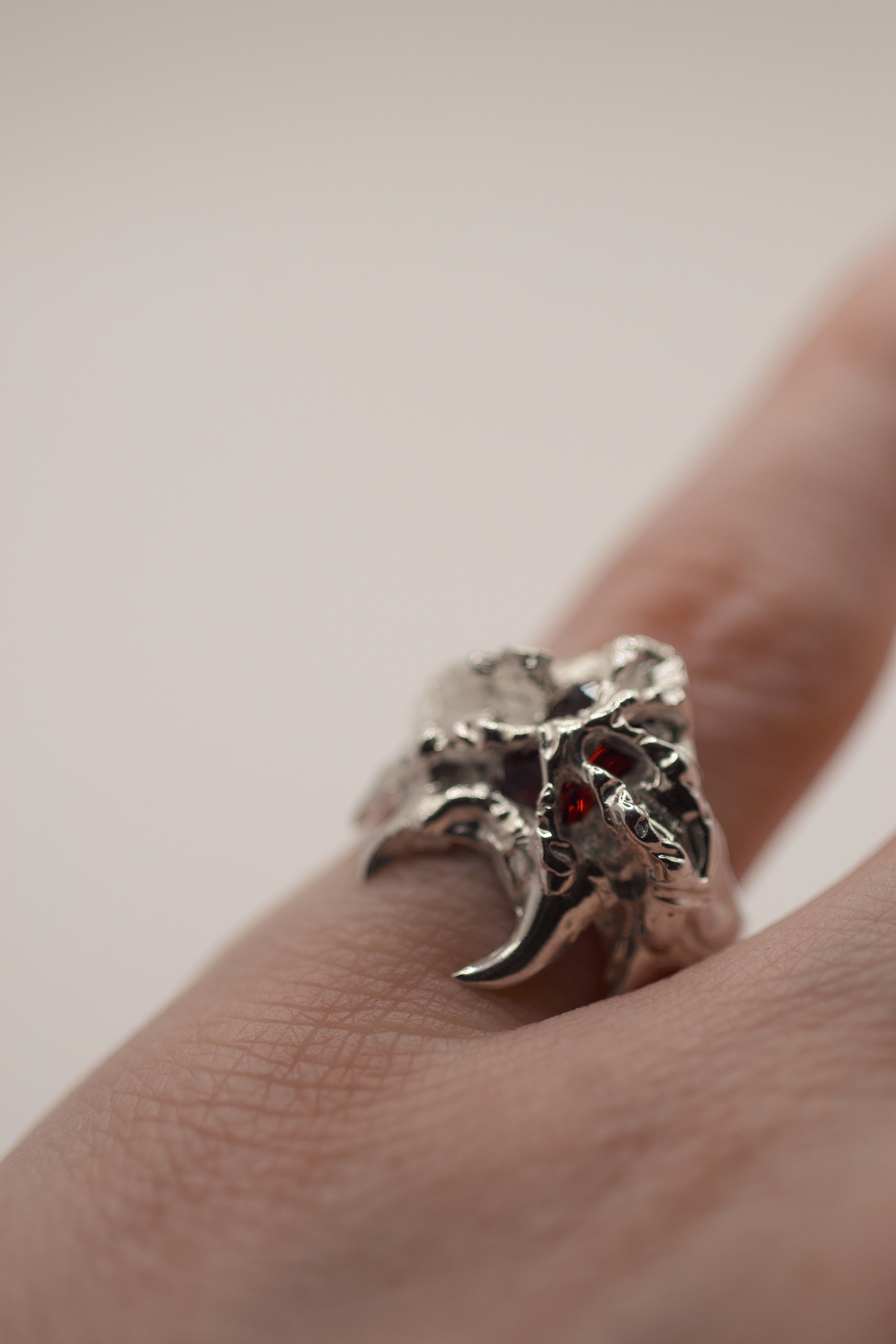 Lost wax cast silver Sacred Ring worn on hand with red lab-grown garnet and raw organic layered silver setting