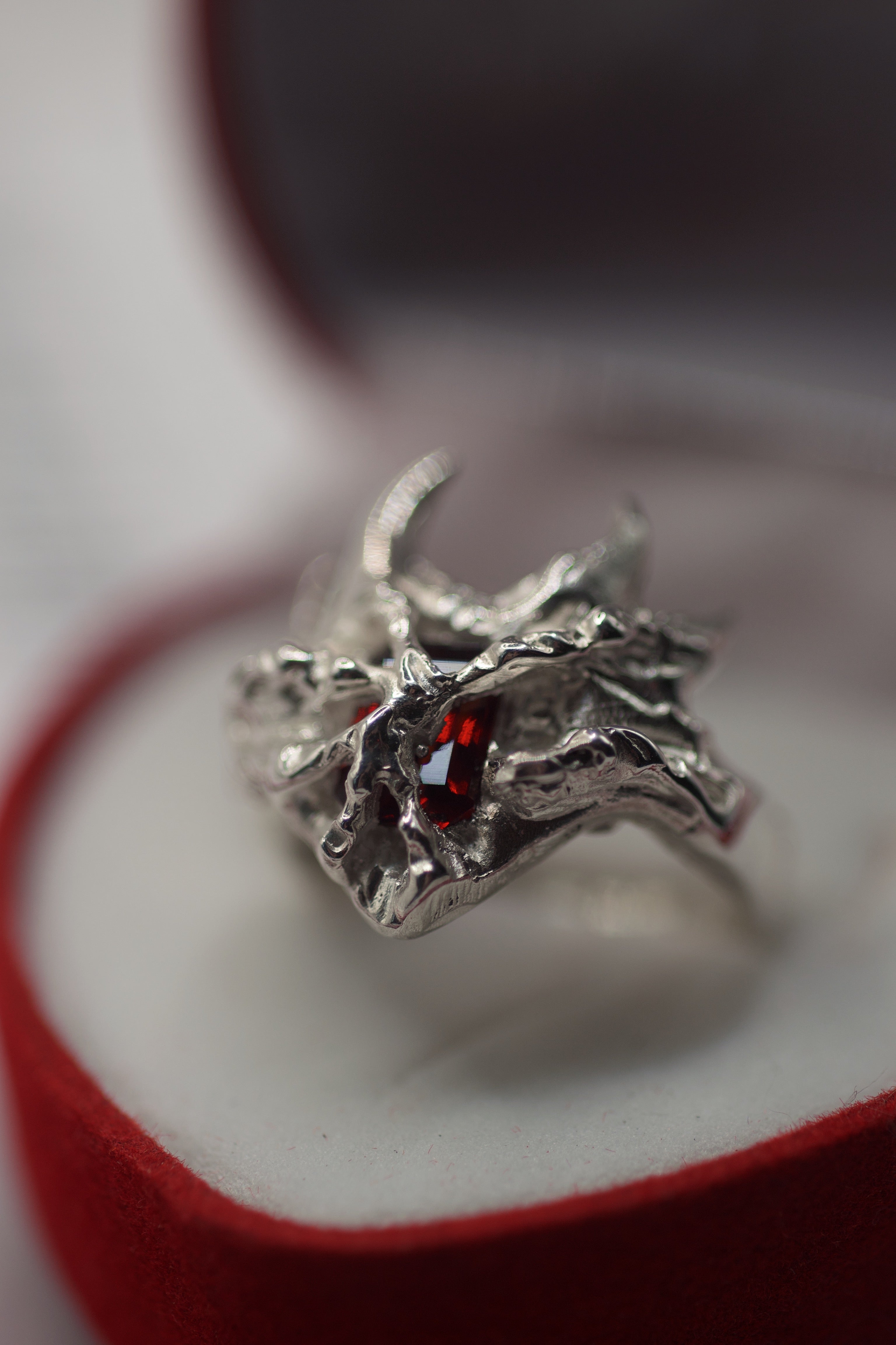 Lost wax cast silver Sacred Ring with red lab-grown garnet in red ring box handmade alternative jewellery using the cast-in-place technique
