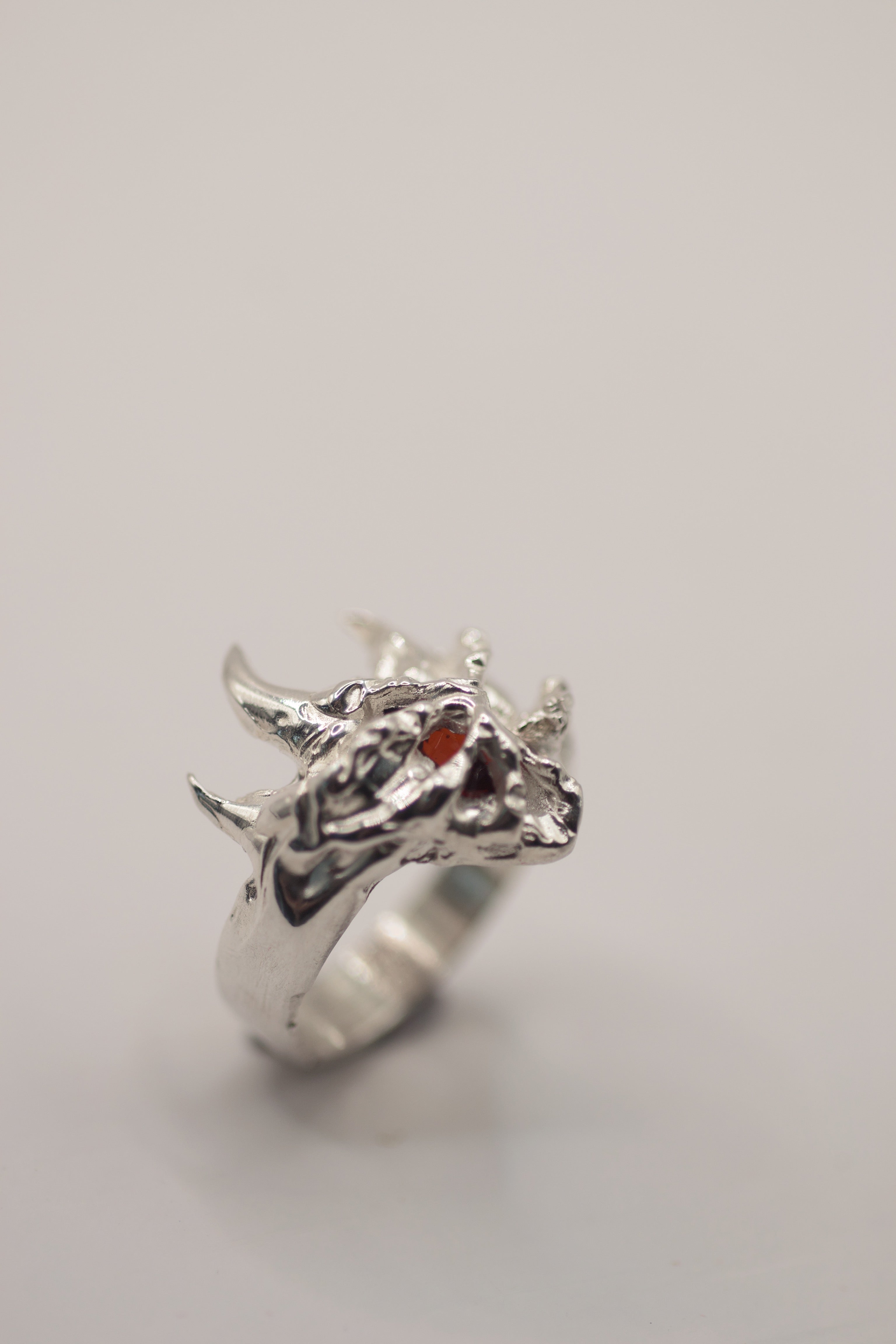 Unique non traditional silver ring Sacred design created using the cast-in-place process with red garnet and organic layered silver