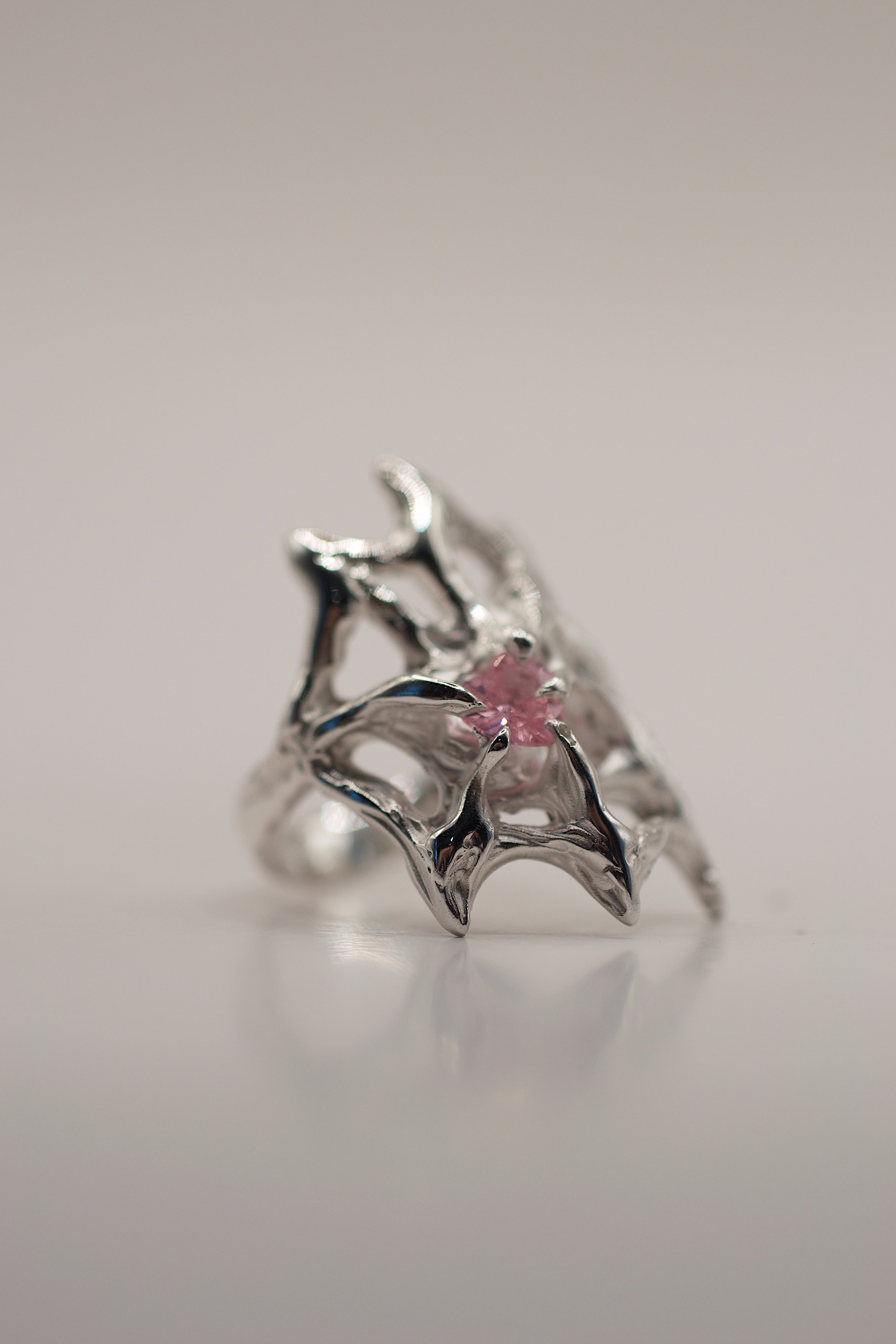 Front view of the Silk Ring showing intricate flowing sterling silver web structure and pink heart cubic zirconia lost wax cast alternative jewellery