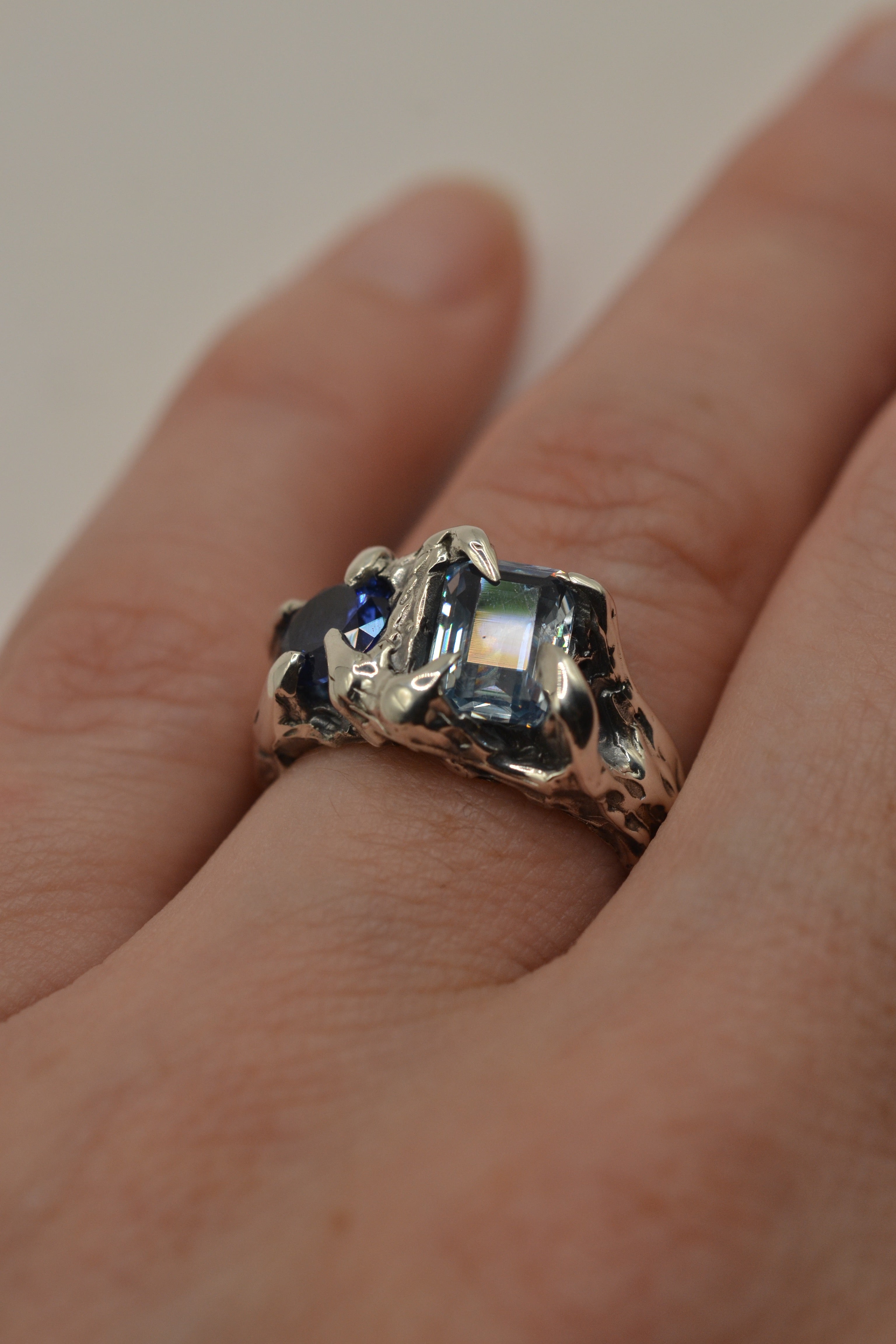 Lost wax cast darkened sterling silver Something Blue Ring worn on hand with natural blue sapphire and blue topaz stones
