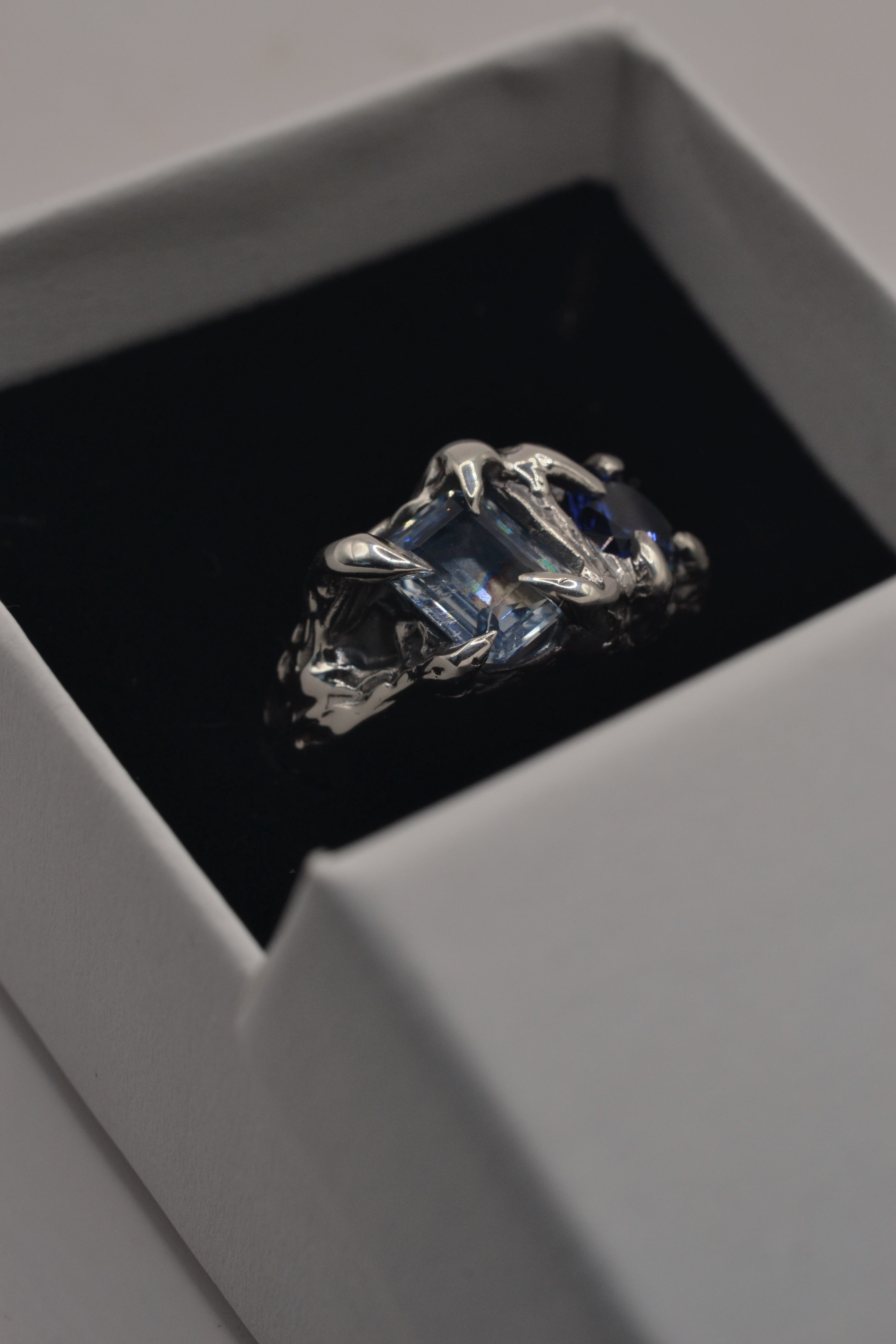 Lost wax cast darkened sterling silver Something Blue Ring in ring box with blue sapphire and topaz stones