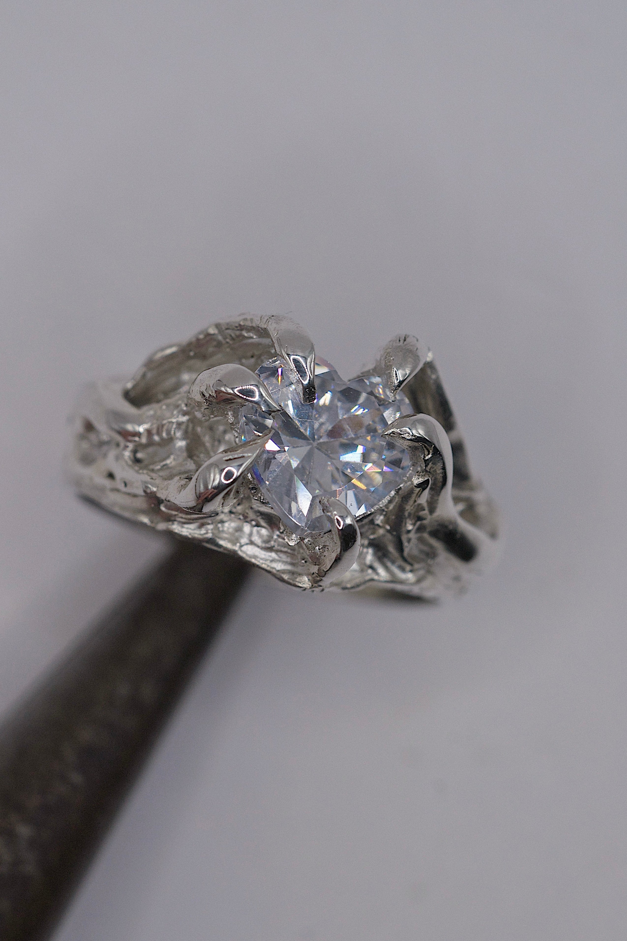 Handmade lost wax cast sterling silver ring with six organic molten claws holding a large heart cubic zirconia, romantic sculptural alternative engagement ring made using the wax carving technique