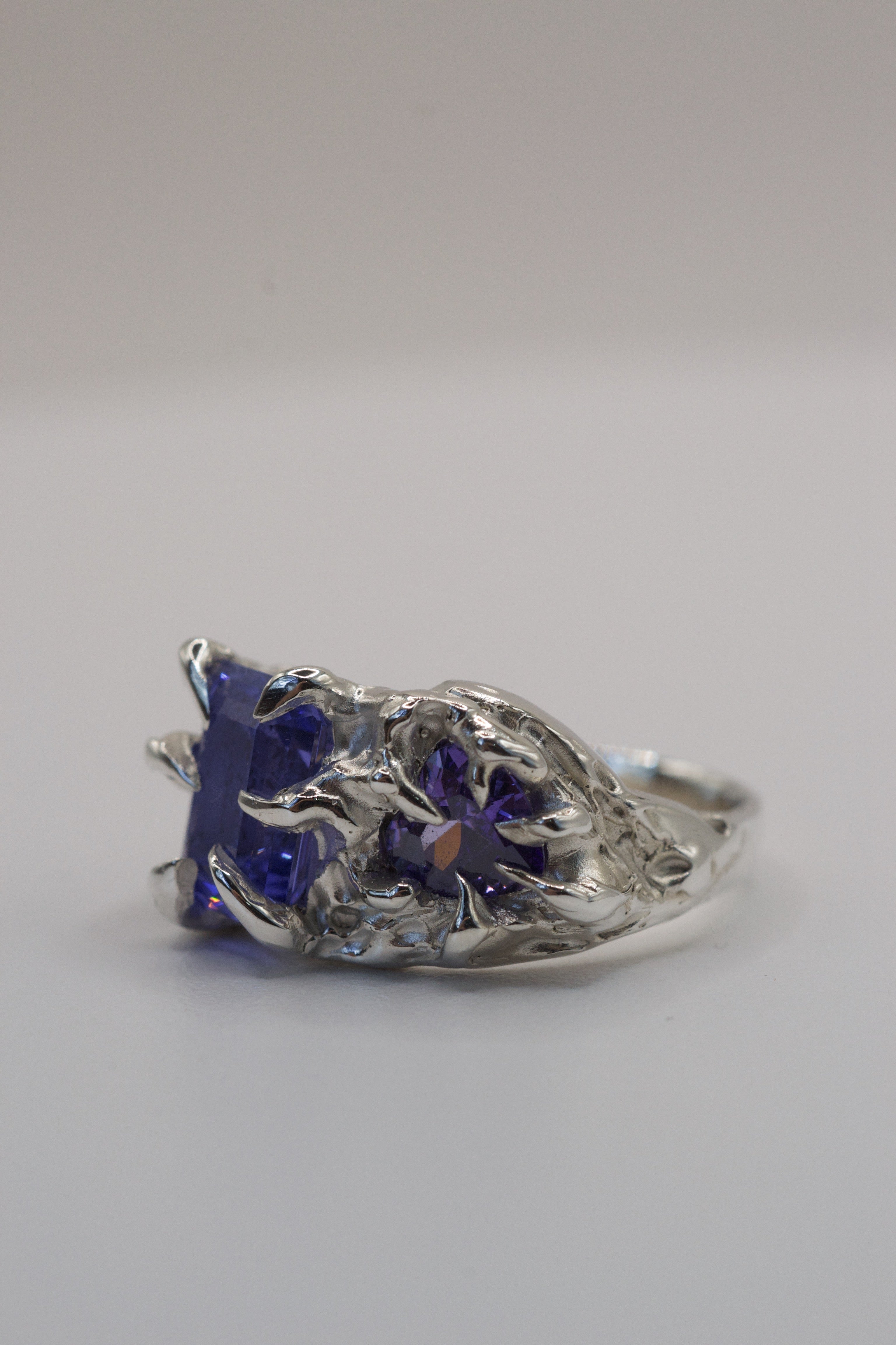 Flat view of the Wilted Ring showing gothic inspired recycled sterling silver band with purple tourmaline and dark romantic detail