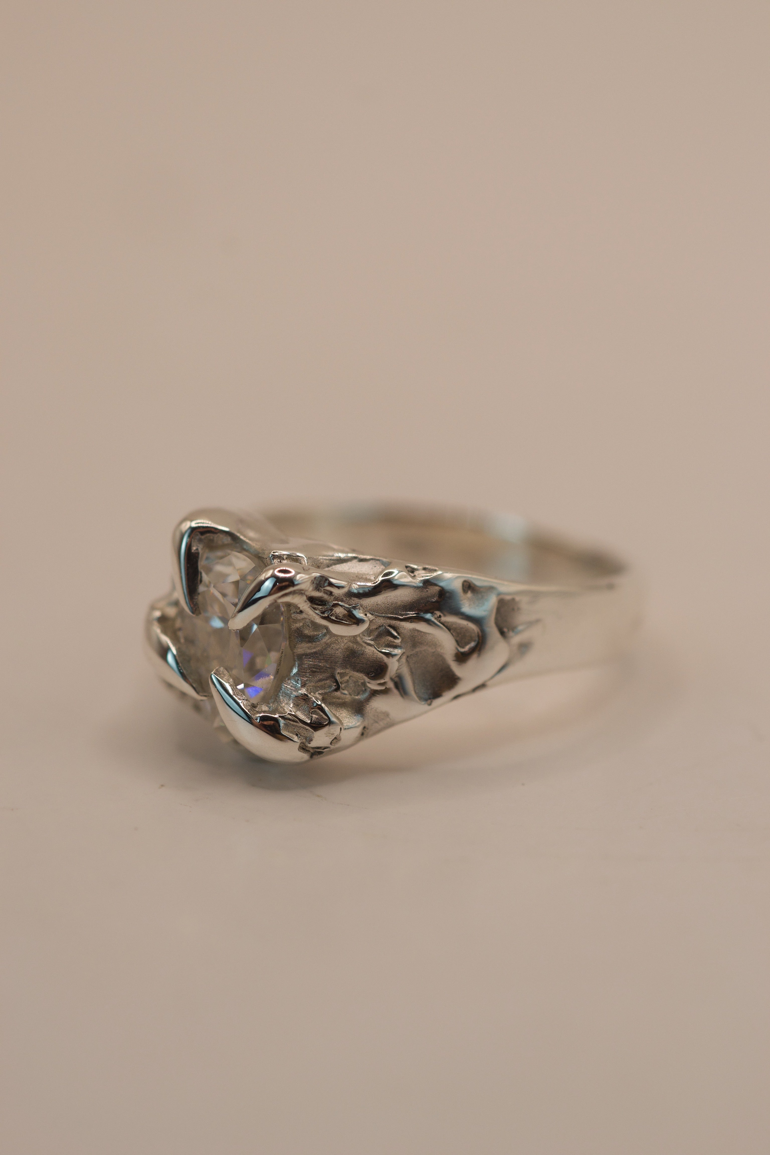 Side angle of the lost wax cast Winter Ring showing organic recycled sterling silver band and pear cut moissanite non traditional engagement ring