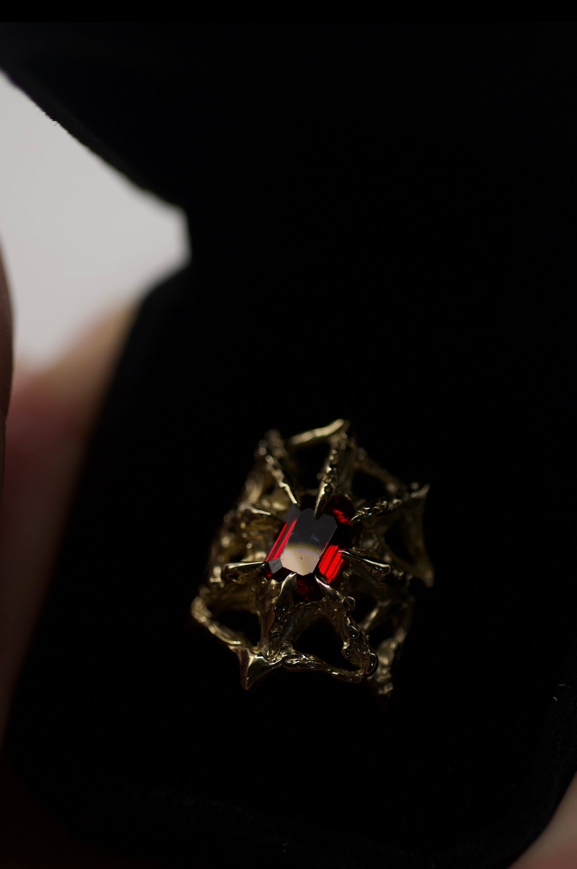 A close-up of the "Doom" Ring’s band, showcasing the texture and sculptural details, all meticulously handcrafted using the lost wax method. The lab-grown emerald garnet is set securely in gothic-style claws, adding to the unique artistry of the piece.