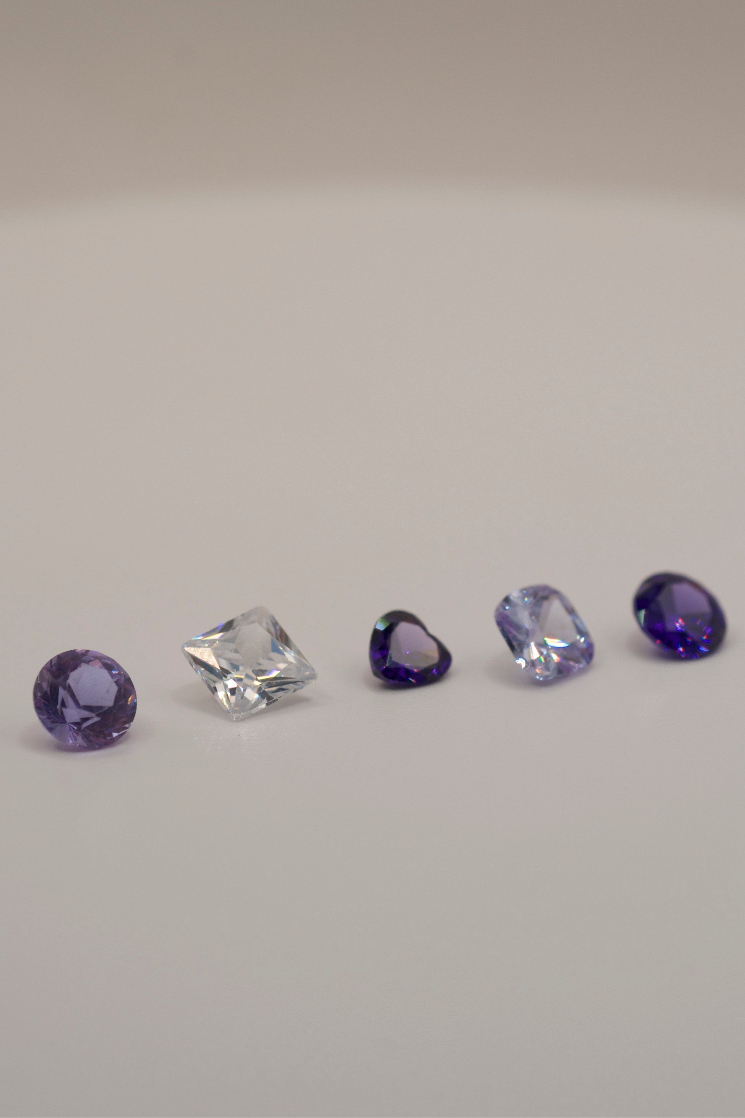 Assorted gemstones for lost wax carving and casting in place, including amethyst tones and clear faceted stones for DIY rings and handmade jewellery.
