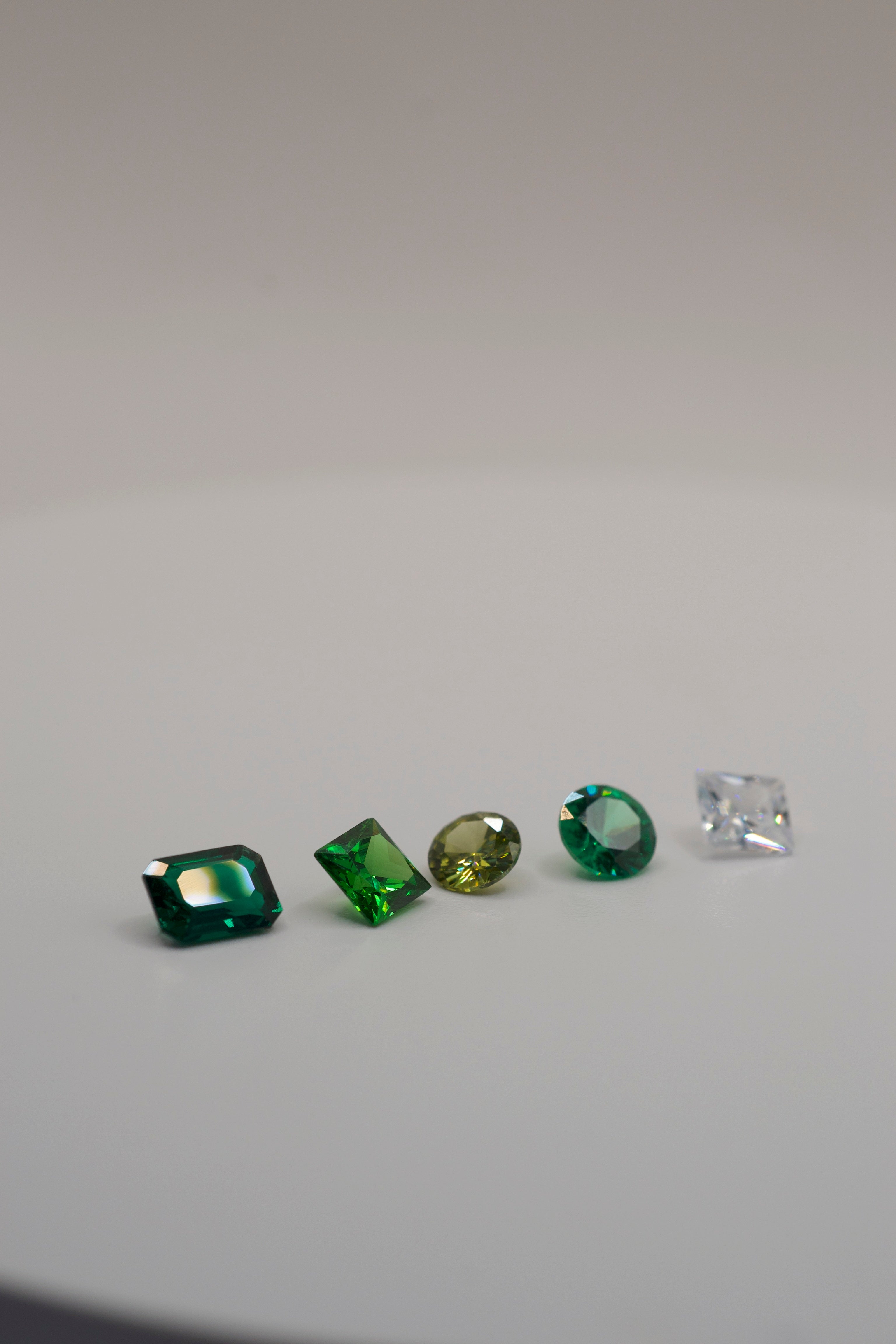 Assorted gemstones for wax carving and cast in place jewelry making, including emerald, square, round, and princess cut stones