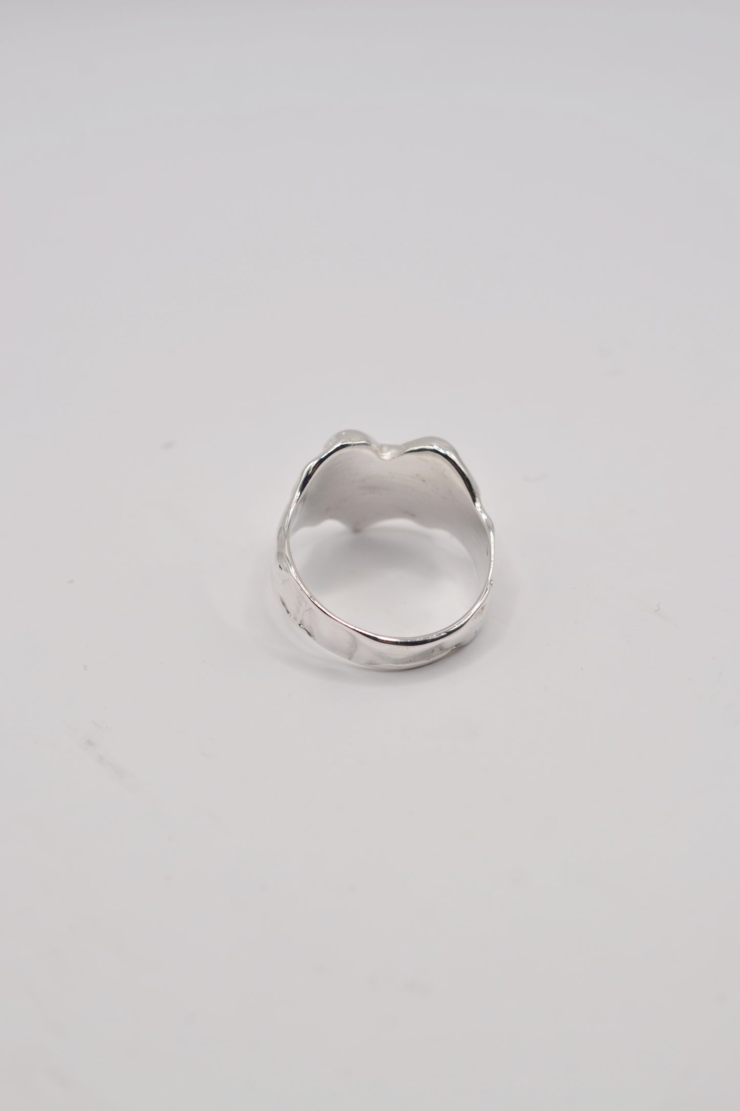 Back view of organic lost wax cast ring in sterling silver with hand carved texture and solid band
