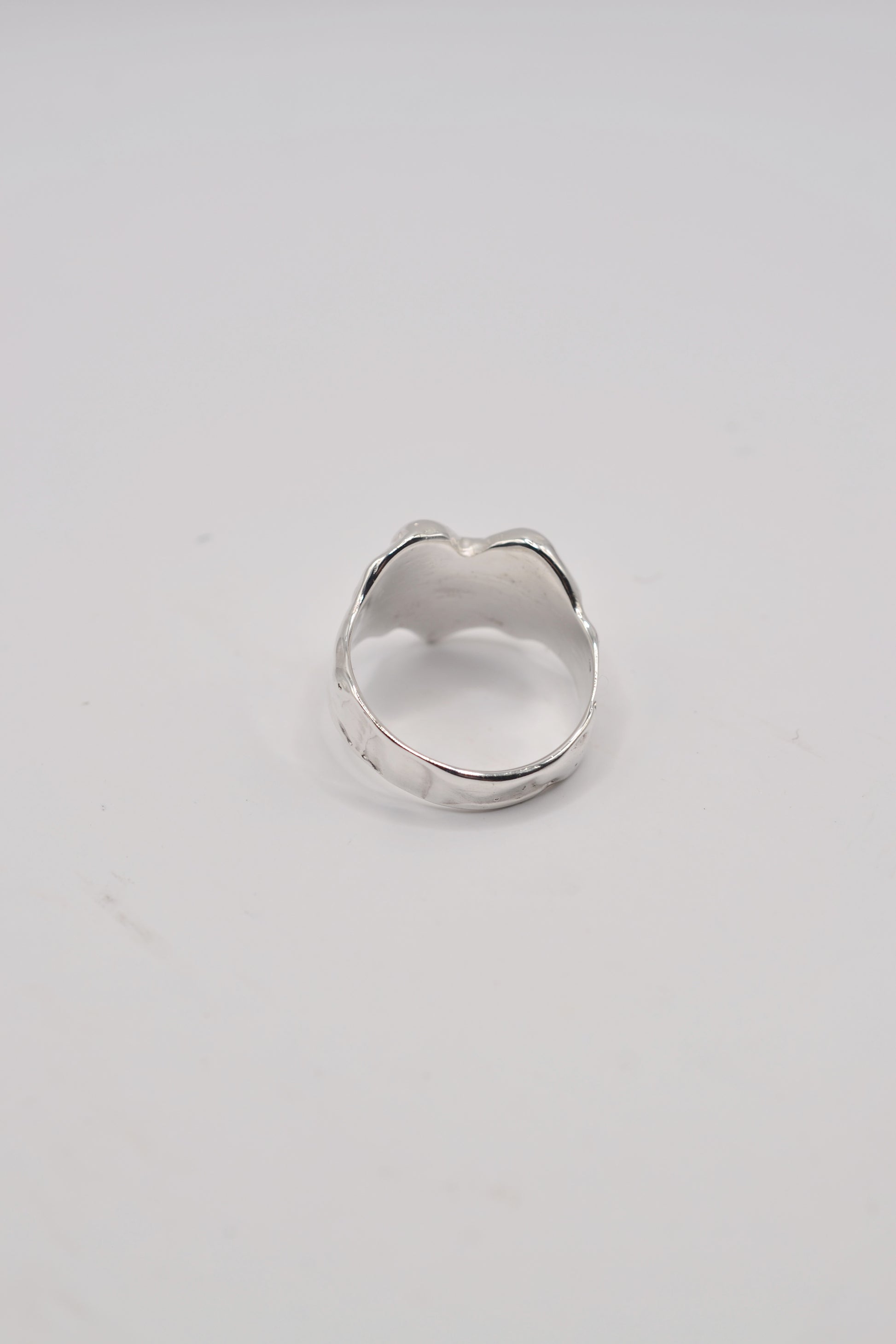 Back view of organic lost wax cast ring in sterling silver with hand carved texture and solid band