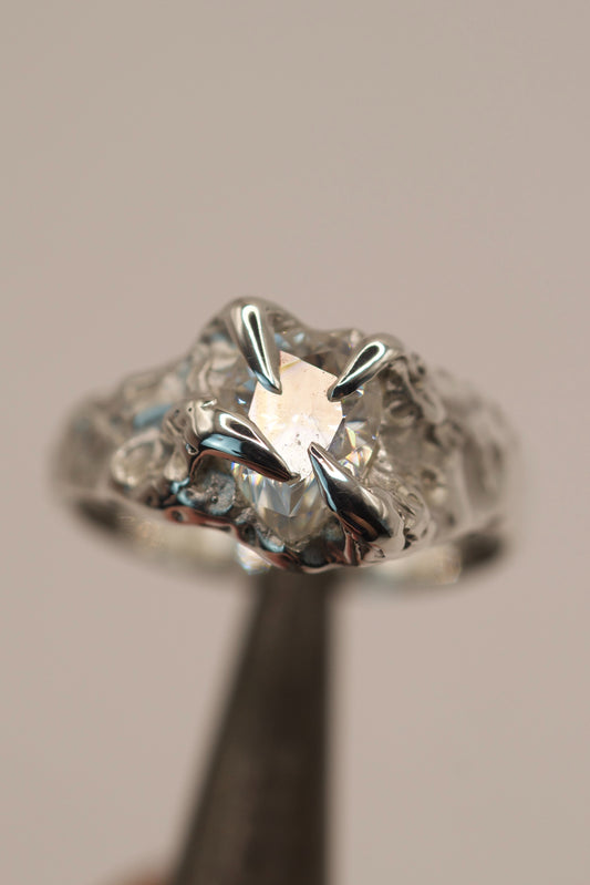 Organic handmade sterling silver engagement ring created with the lost wax process, featuring gothic inspired claws around a pear cut moissanite.