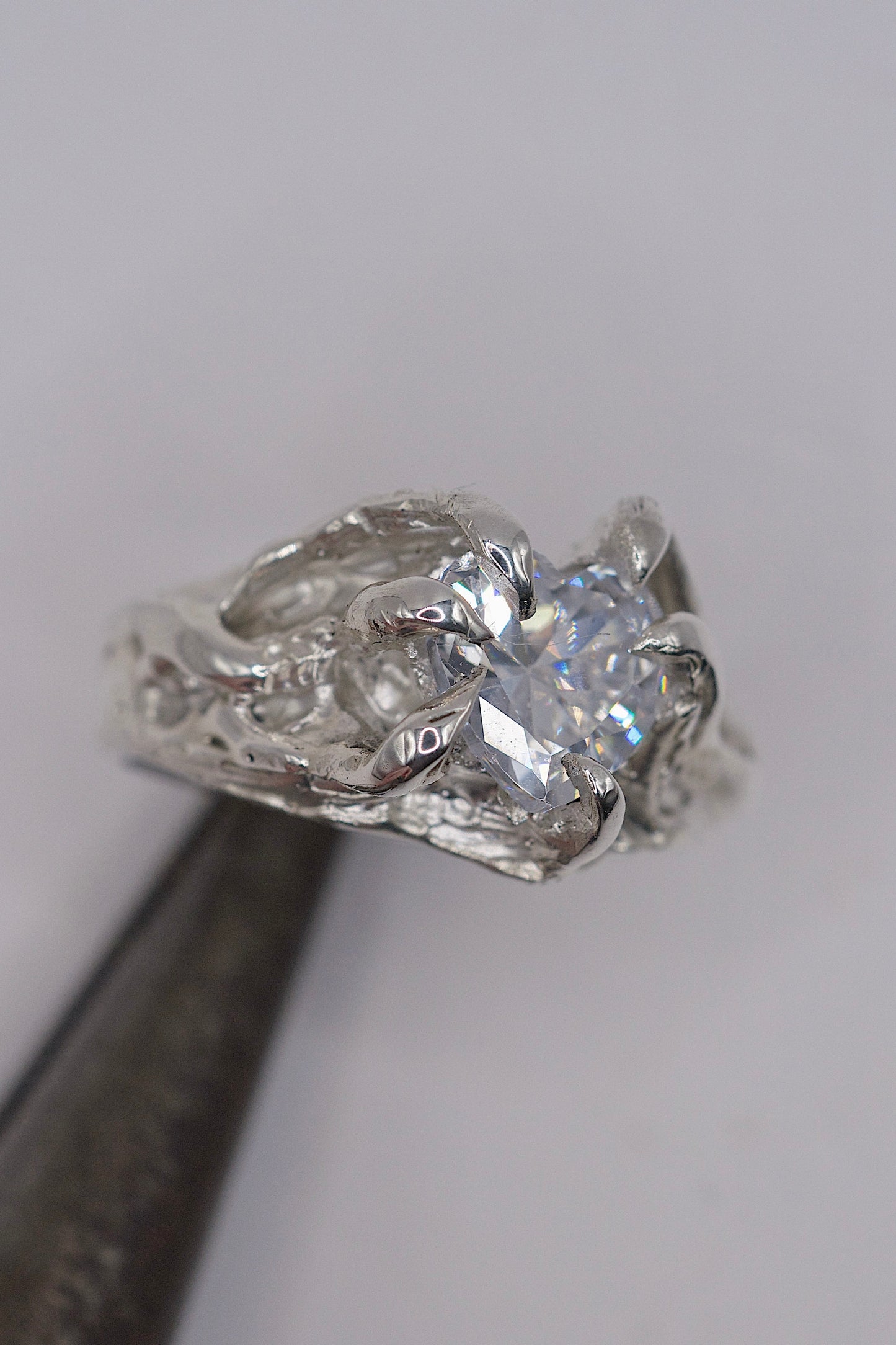 Lost wax carved sterling silver ring with gothic claws, molten texture, and a heart-shaped clear cubic zirconia crystal in an organic, handmade setting.