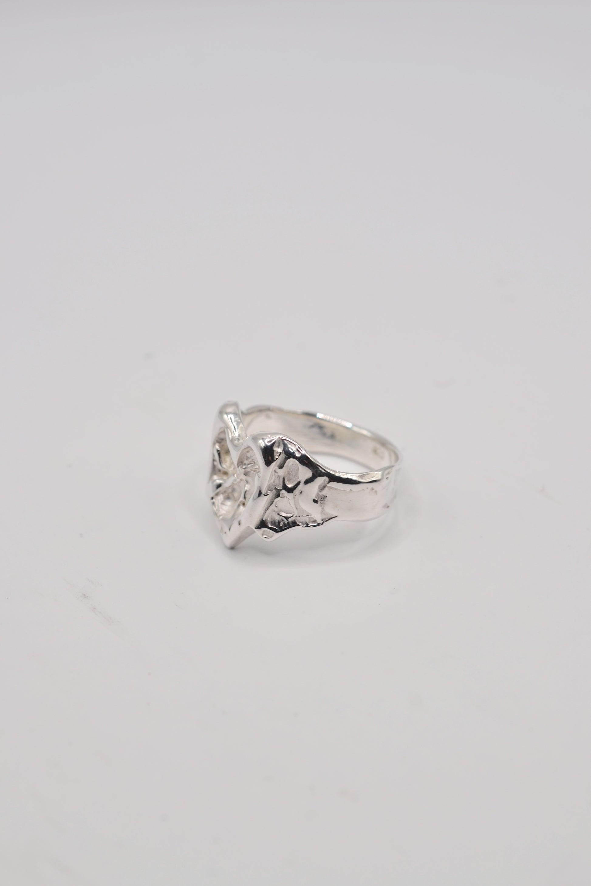 Side view of organic lost wax cast ring in sterling silver showing sculpted band and molten heart detail