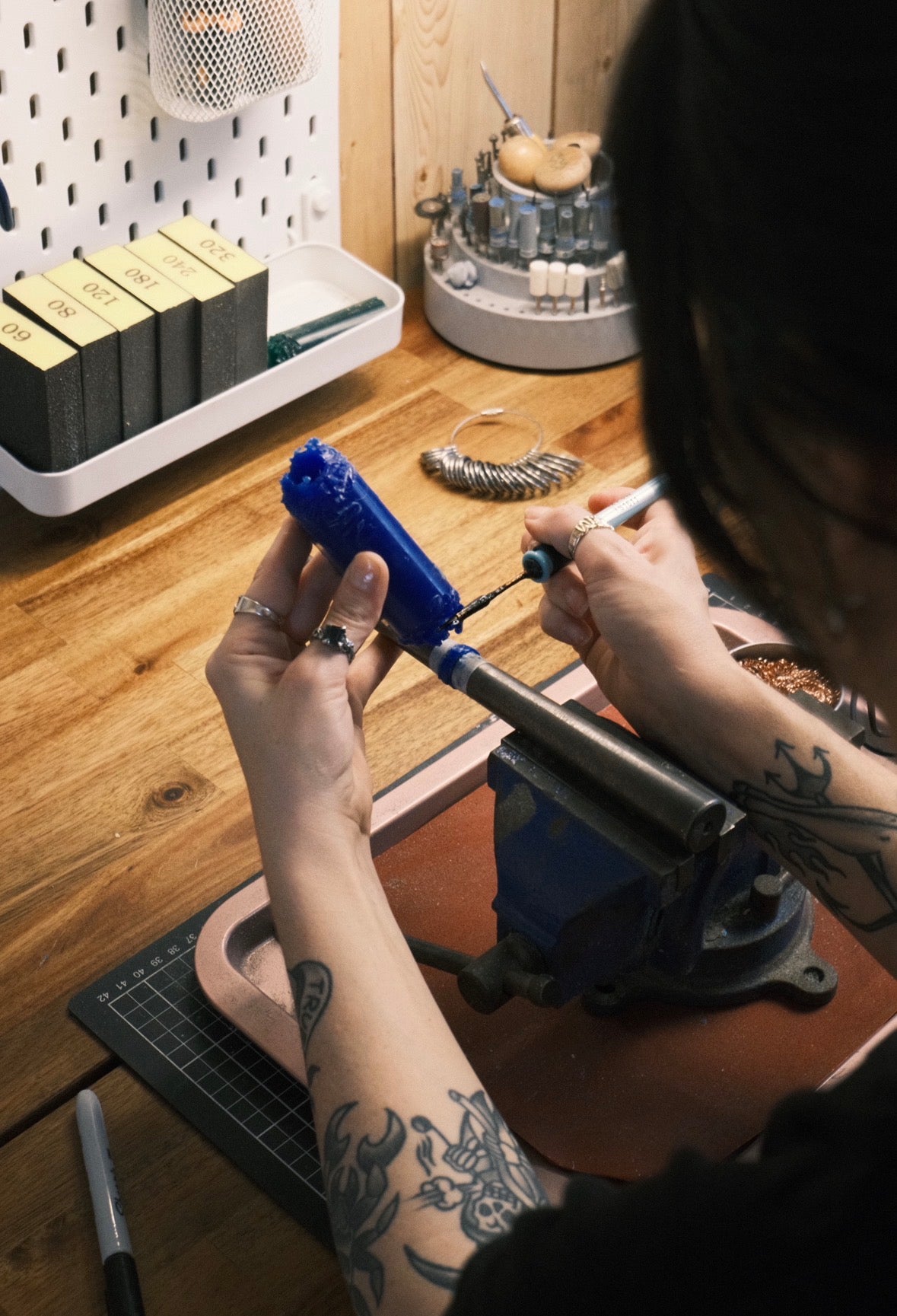 Jewellery maker melting jewellers wax with a soldering iron on a mandrel during the lost wax jewellery making process.