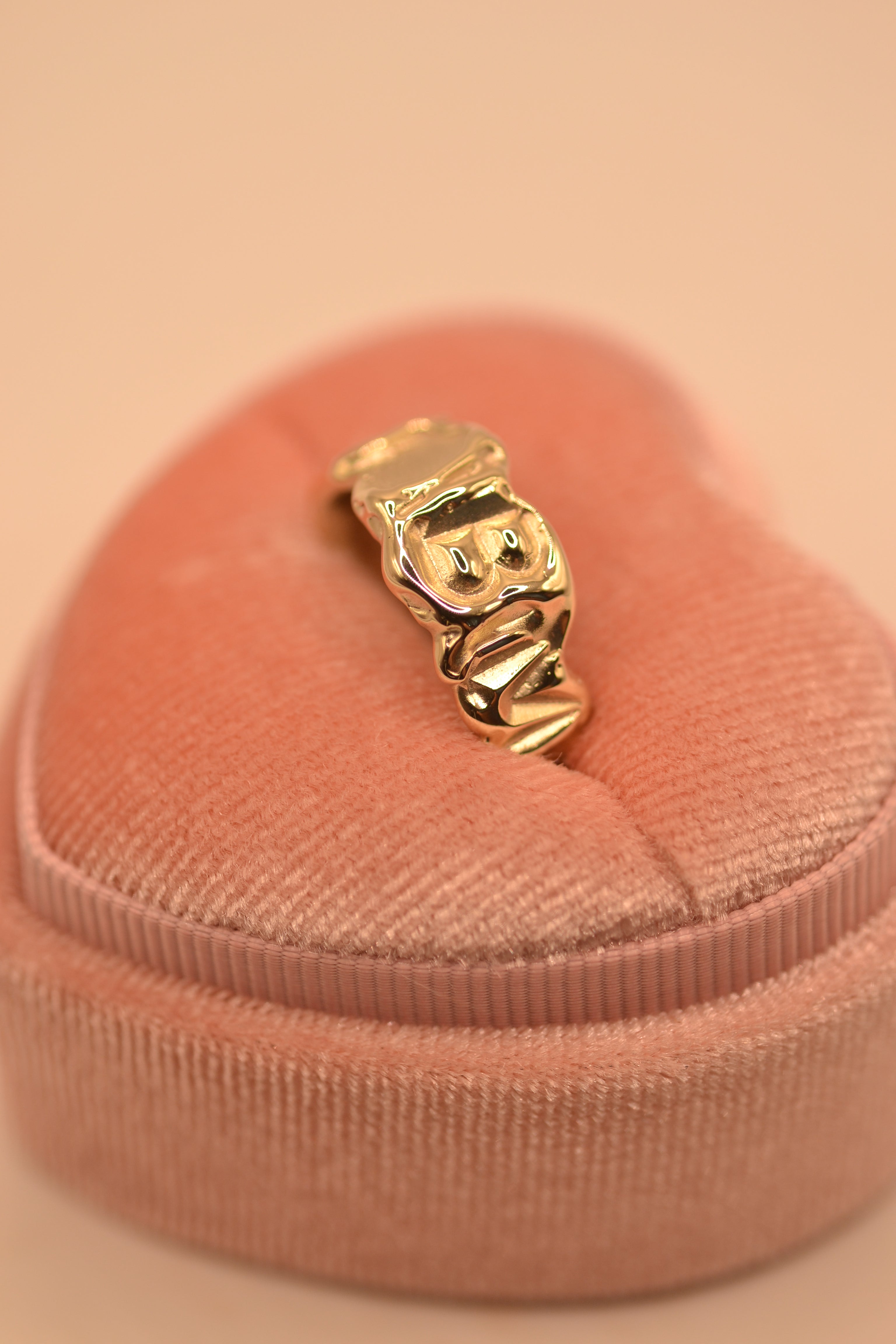 Recycled gold personalised band ring sitting on soft surface showing sculptural handmade detail