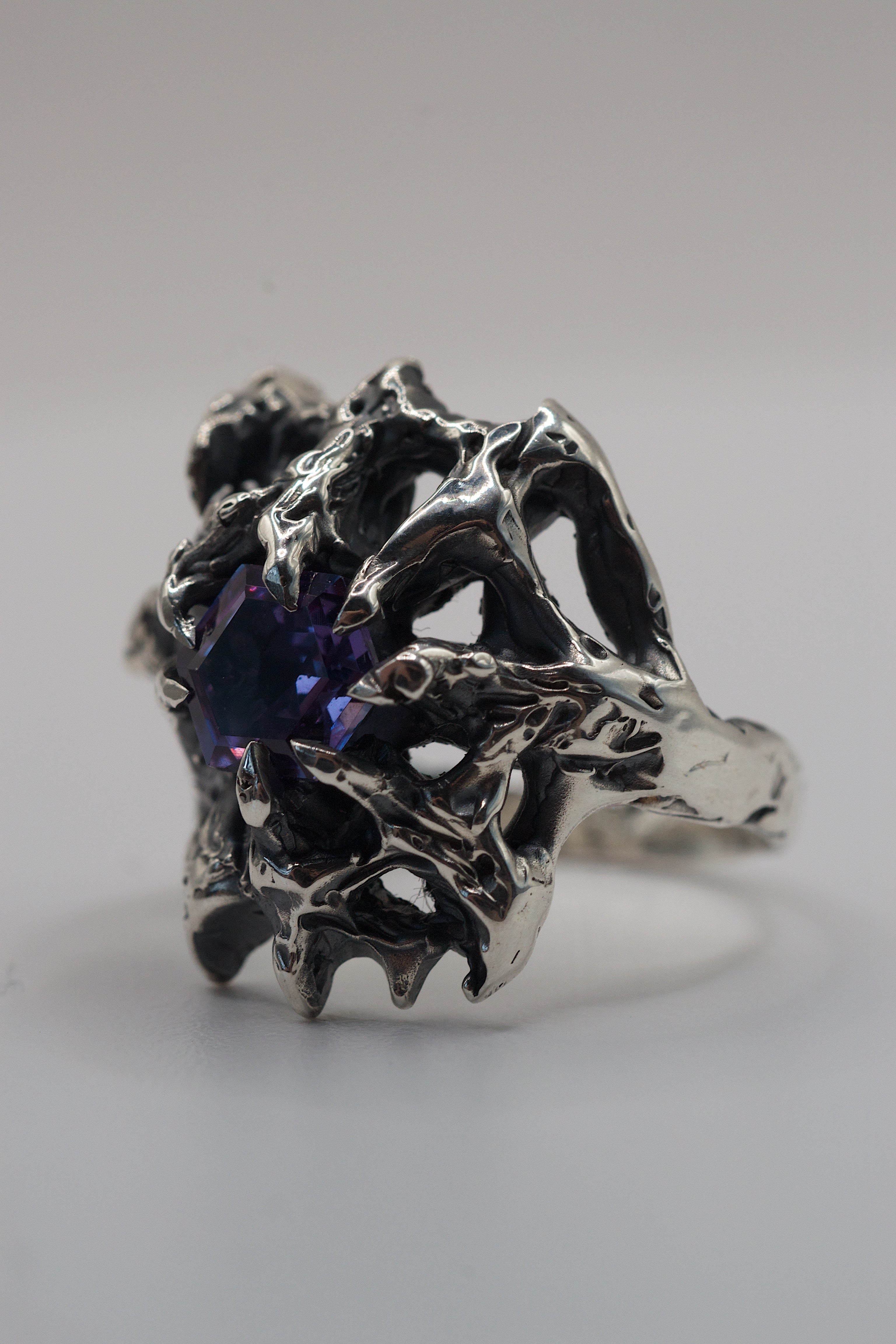 Lost wax cast silver ring with 10 claw prongs securing a purple alexandrite and a sparkling cubic zirconia heart.