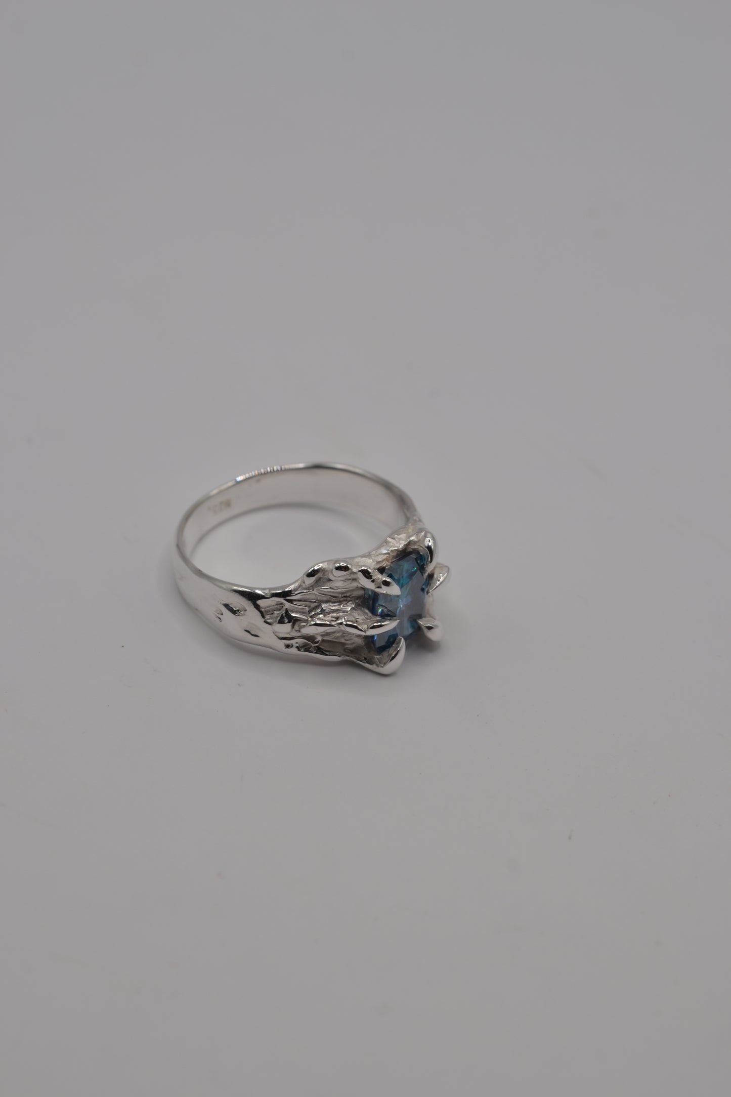 Organic alternative silver ring handcrafted using the lost wax technique, highlighting textured band details and moissanite setting.