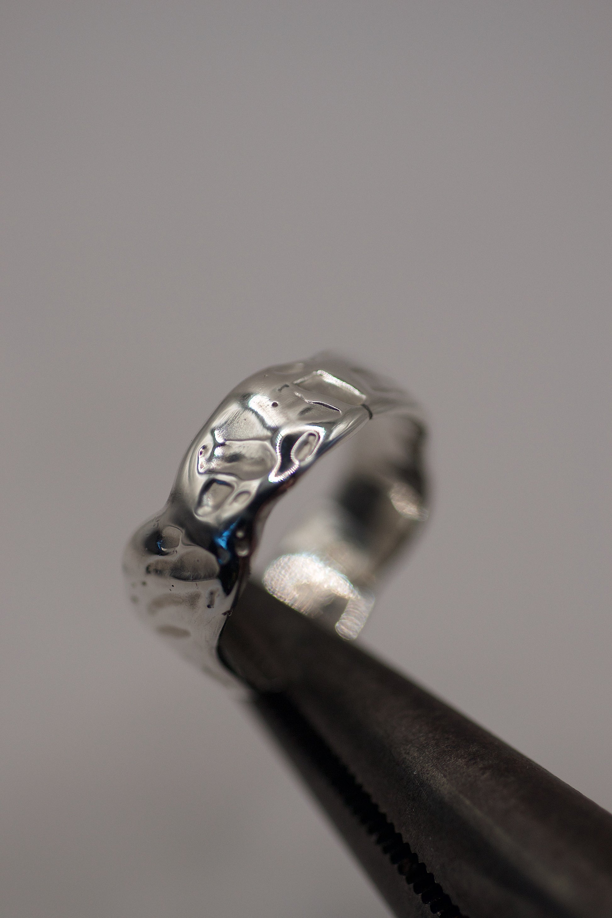 Close-up of organic molten textured sterling silver ring made using the lost wax jewellery technique